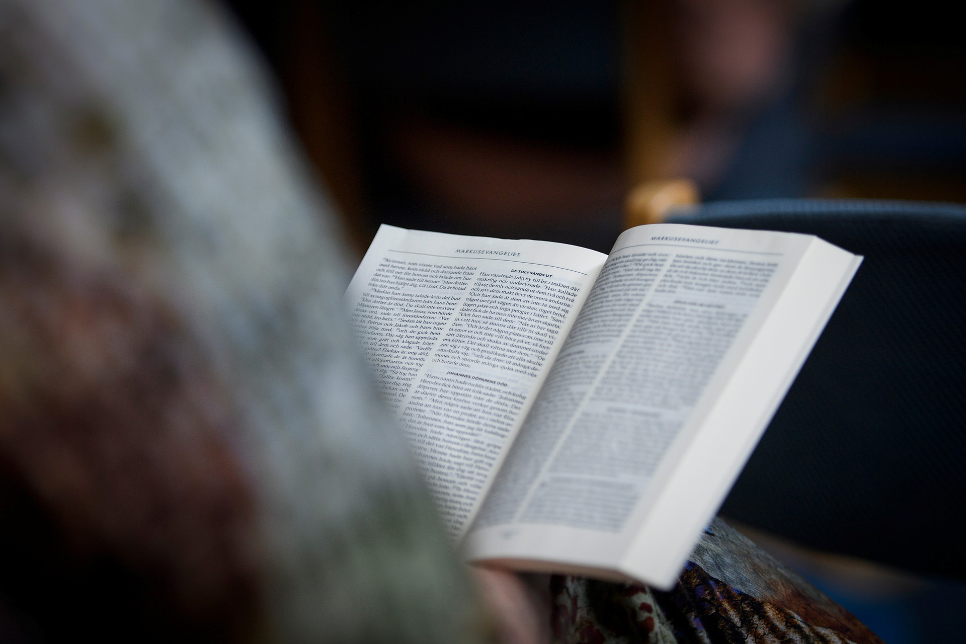 En person läser i en Bibel.