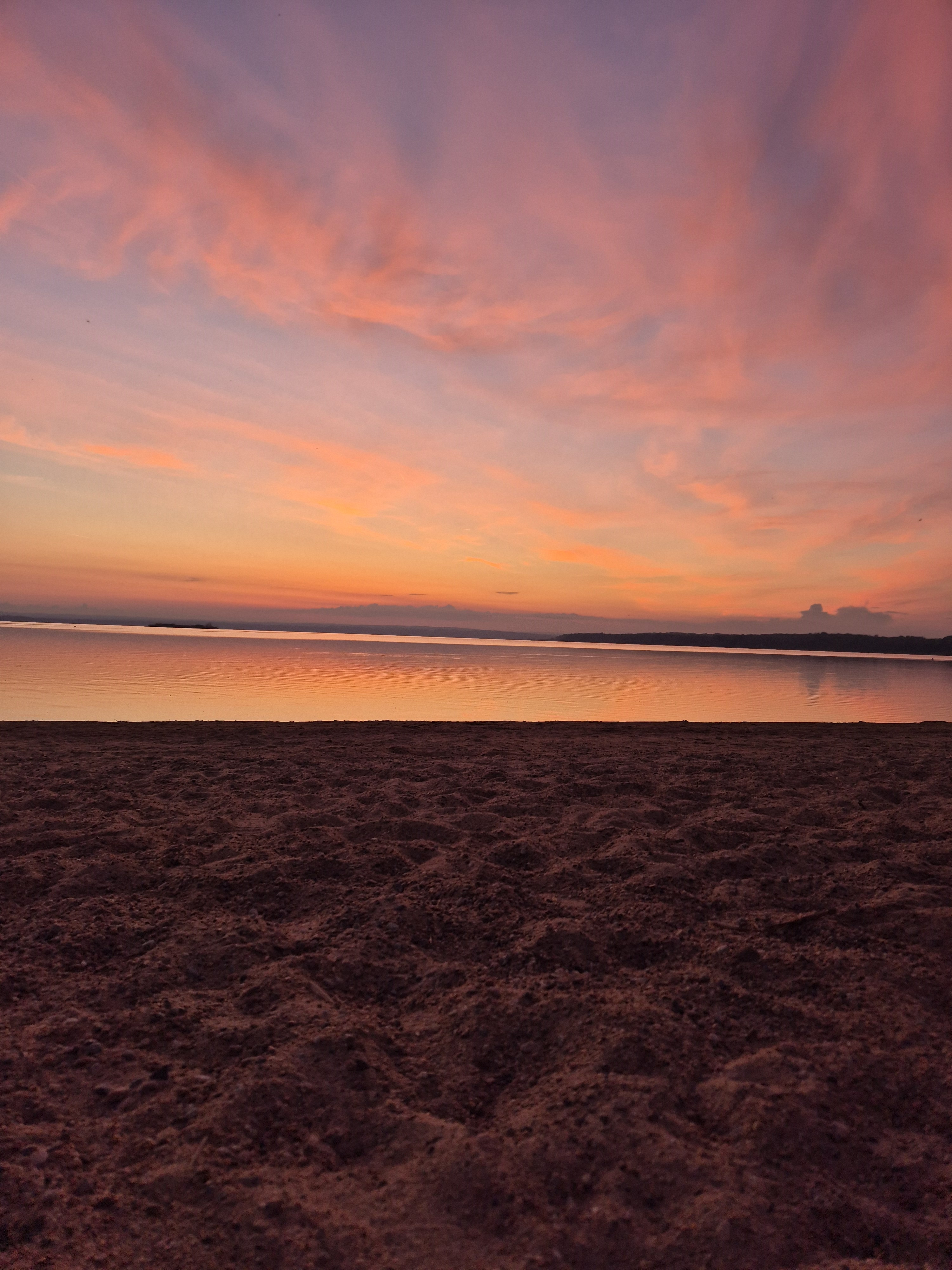 Solnedgång över vattnet färgar himlen i vackra kulörer