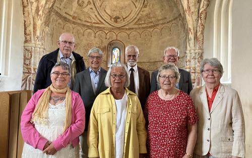 Kvinnor och män i somriga kläder i koret i Hästveda kyrka.