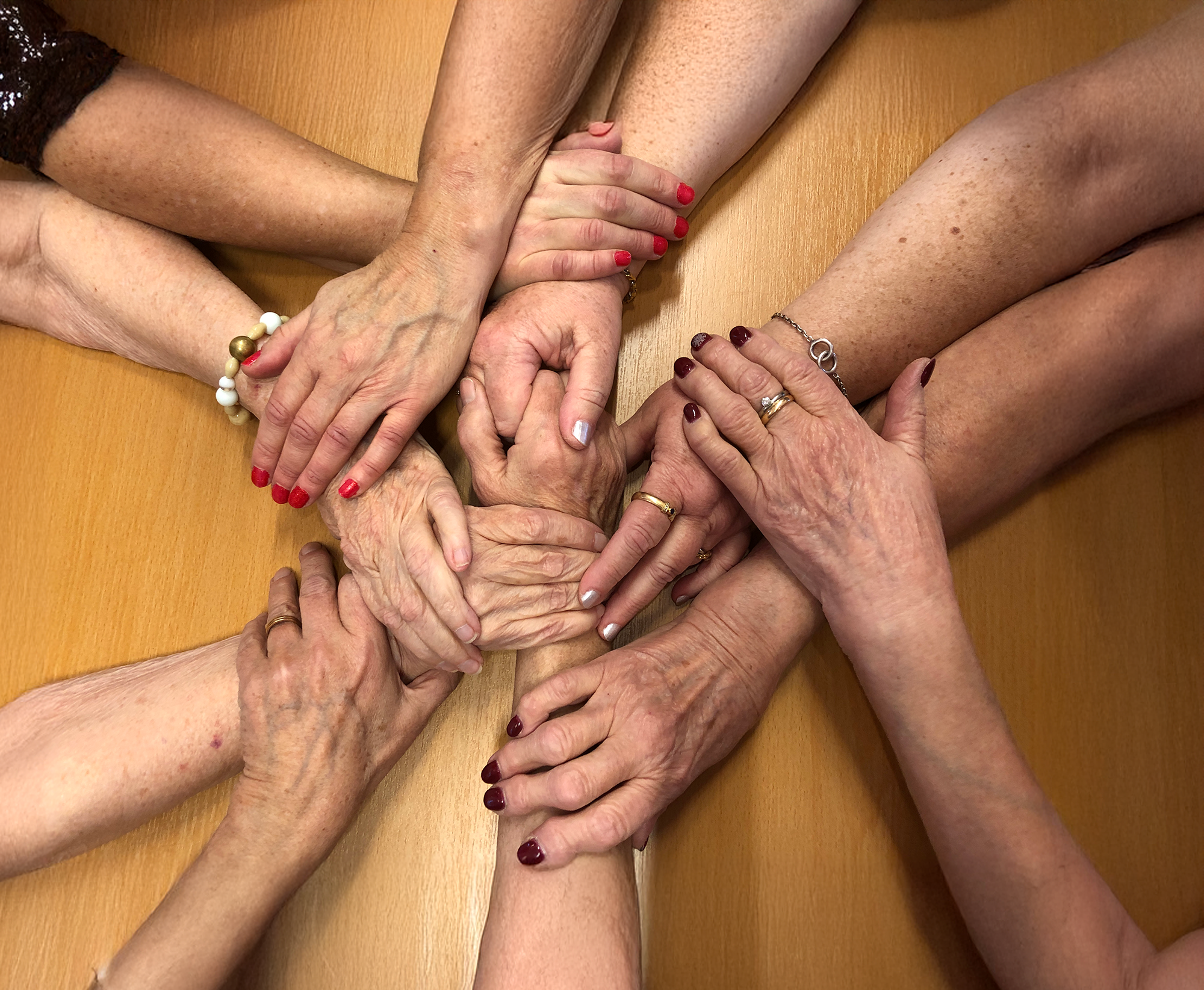 Händer från flera olika människor som håller i varandra.