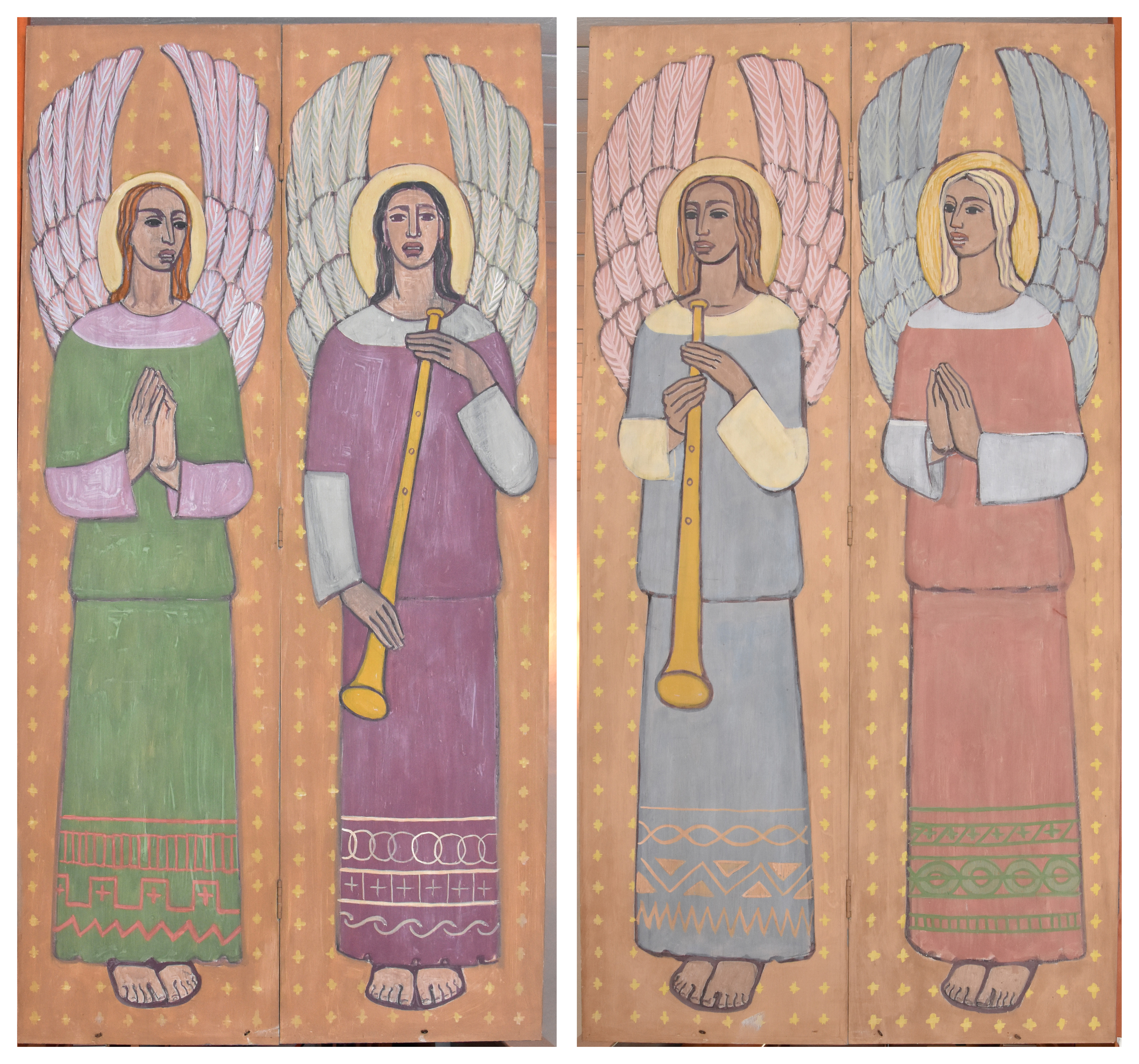 Fyra änglagestalter med vingar som står rätt upp. En ängel har grön klädnad, en lila, en blå och en ljust röd. De två änglarna i mitten håller i långa blåsinstrument.