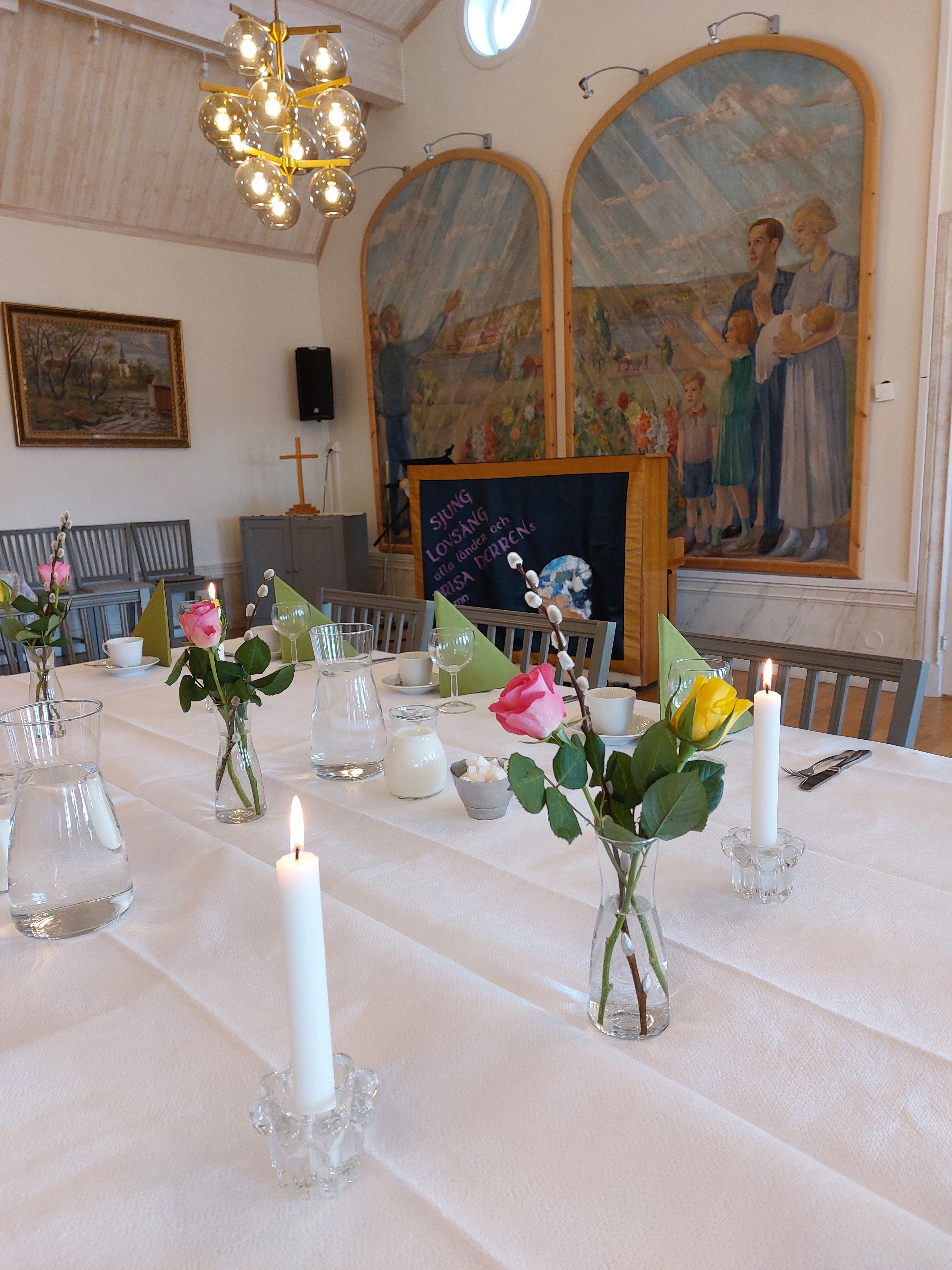 Bord dukat med gula och rosa rosor till minnesstund