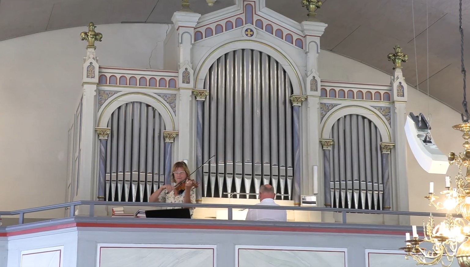 Fiol- och orgelmusik ljuder från läktaren i Långelanda kyrka.