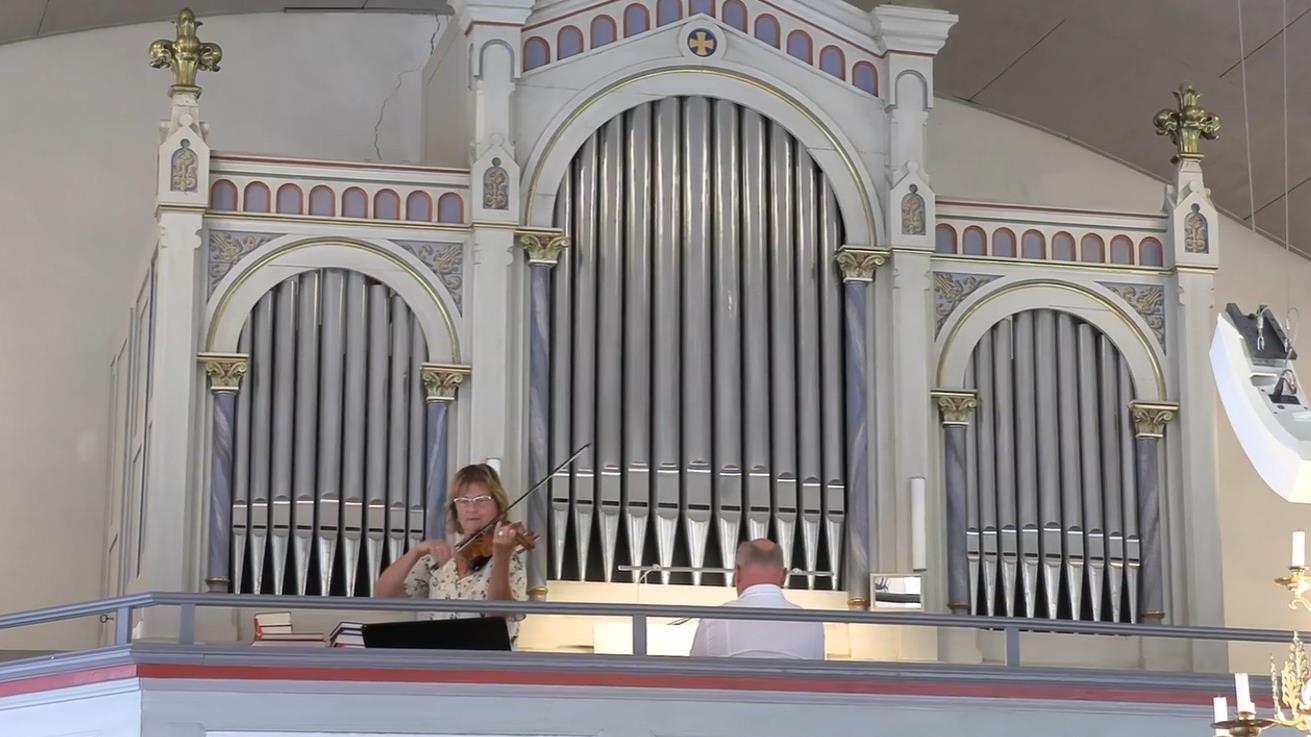 Fiol- och orgelmusik ljuder från läktaren i Långelanda kyrka.