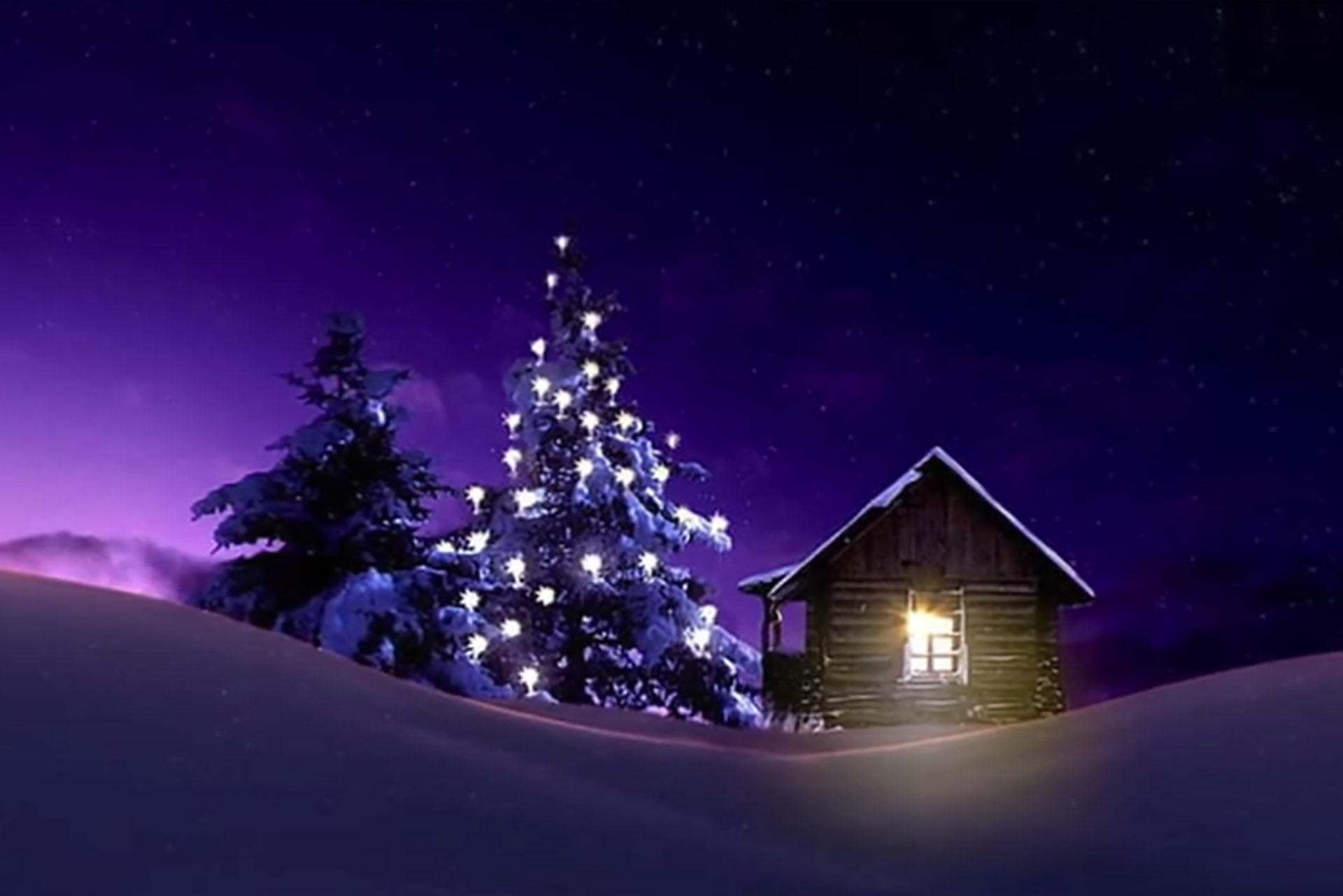Bild på en snöig stuga med julgran