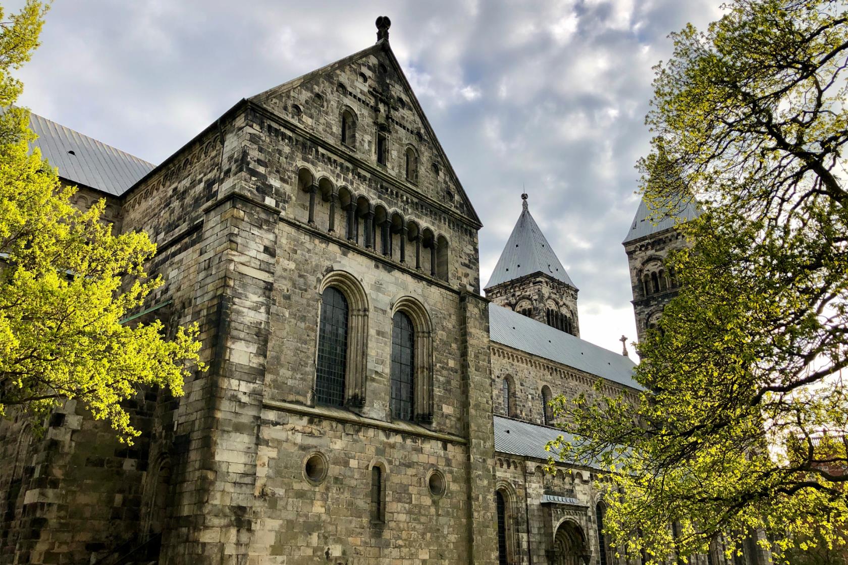 Lunds domkyrka från nordost. Träden syns gröna i Lundagård.