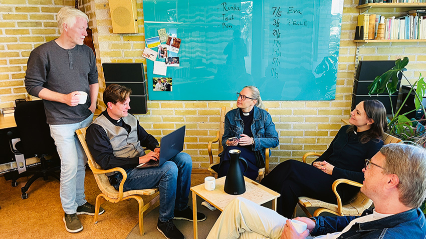 Två kvinnor och tre män diskuterar.