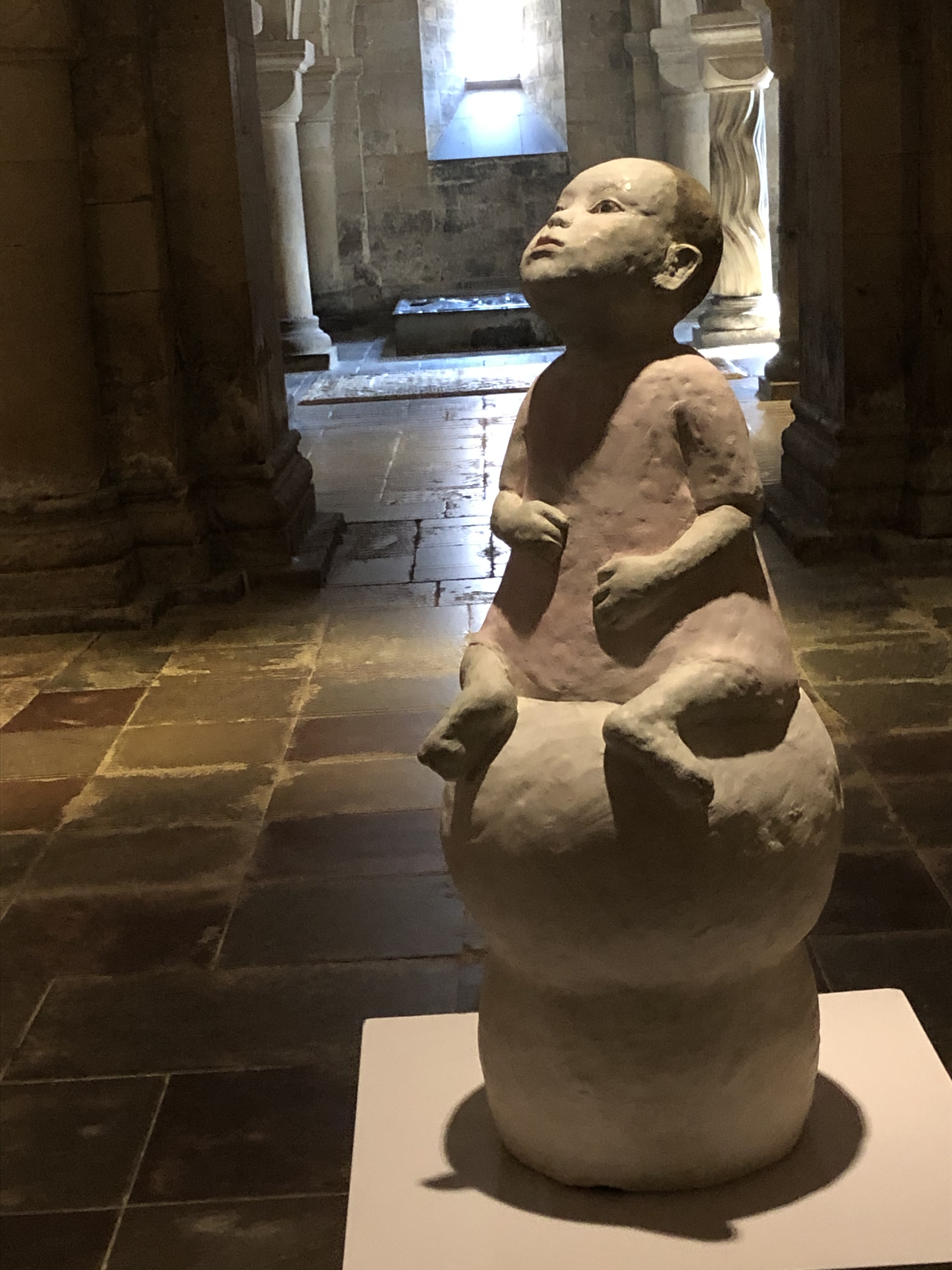 En lerfigur i form av ett barn i naturlig storlek placerad i kryptan.