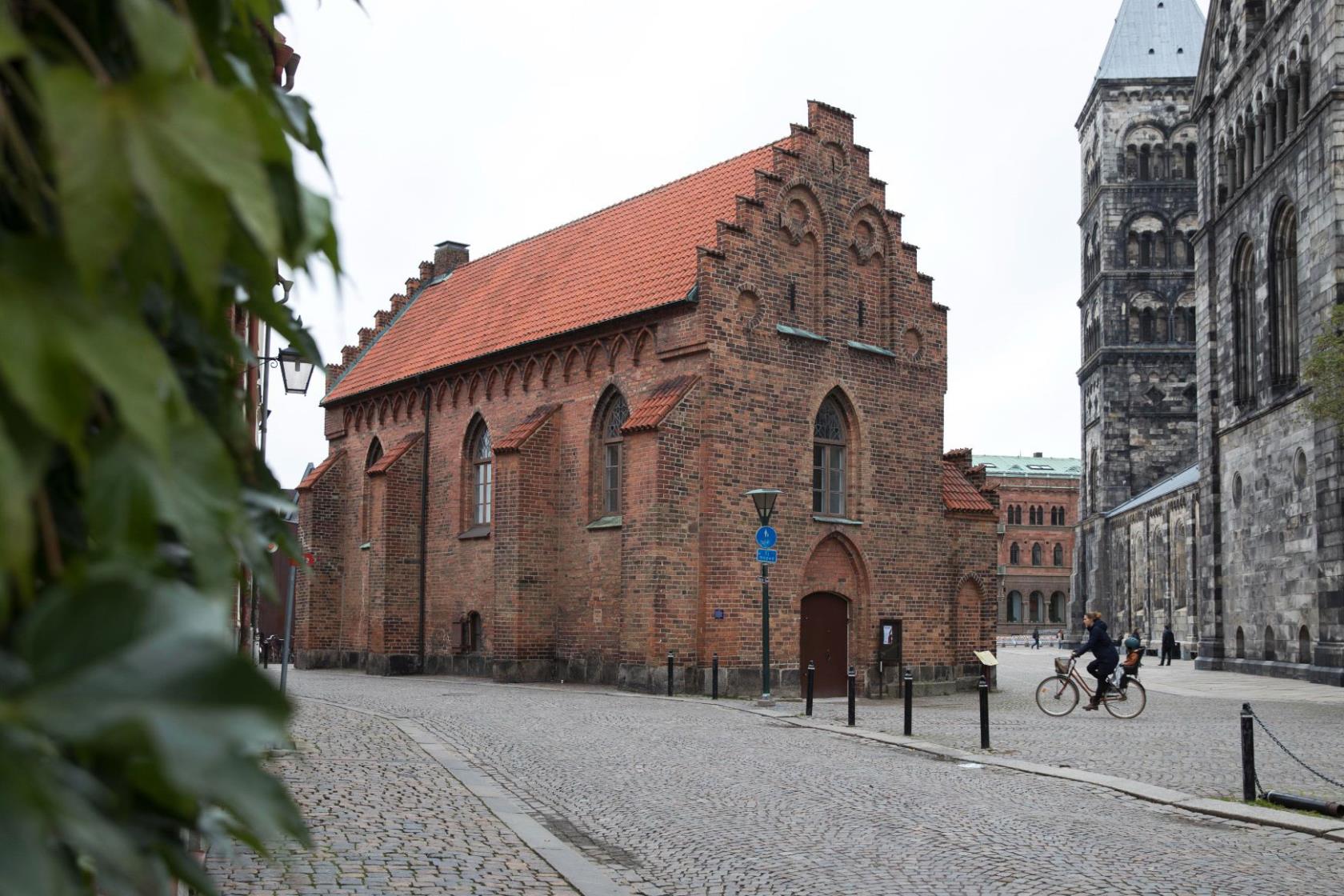 Röd tegelbyggnad med rött tegeltak och trappstensgavlar.