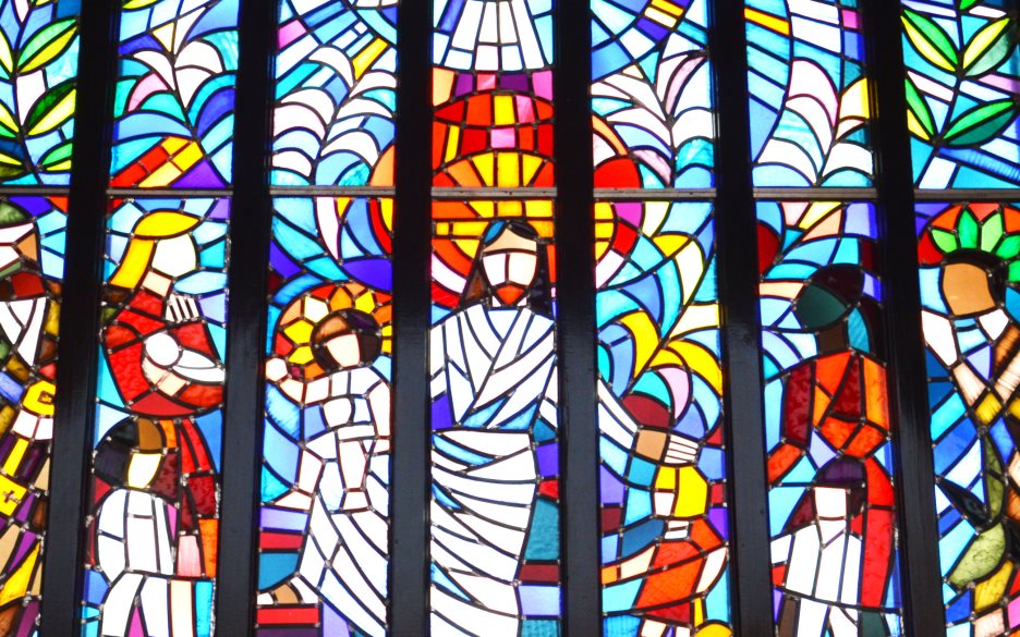Det färgglada fönstret i Petersgårdens kyrka. Här är evangeliet om Jesus och barnet illustrerat.