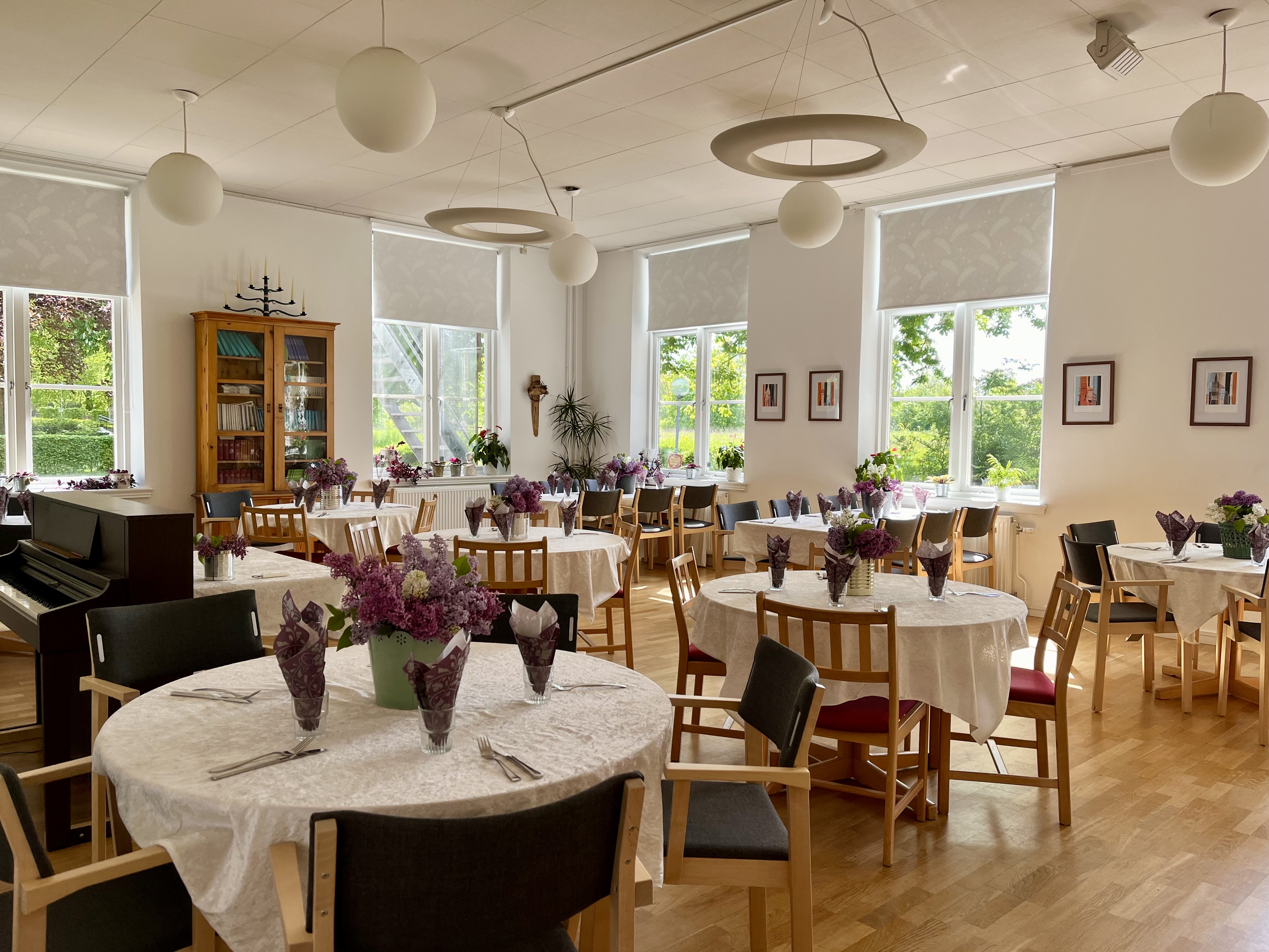 Dukat med vita dukar och blommor i Nöbbelövsgården