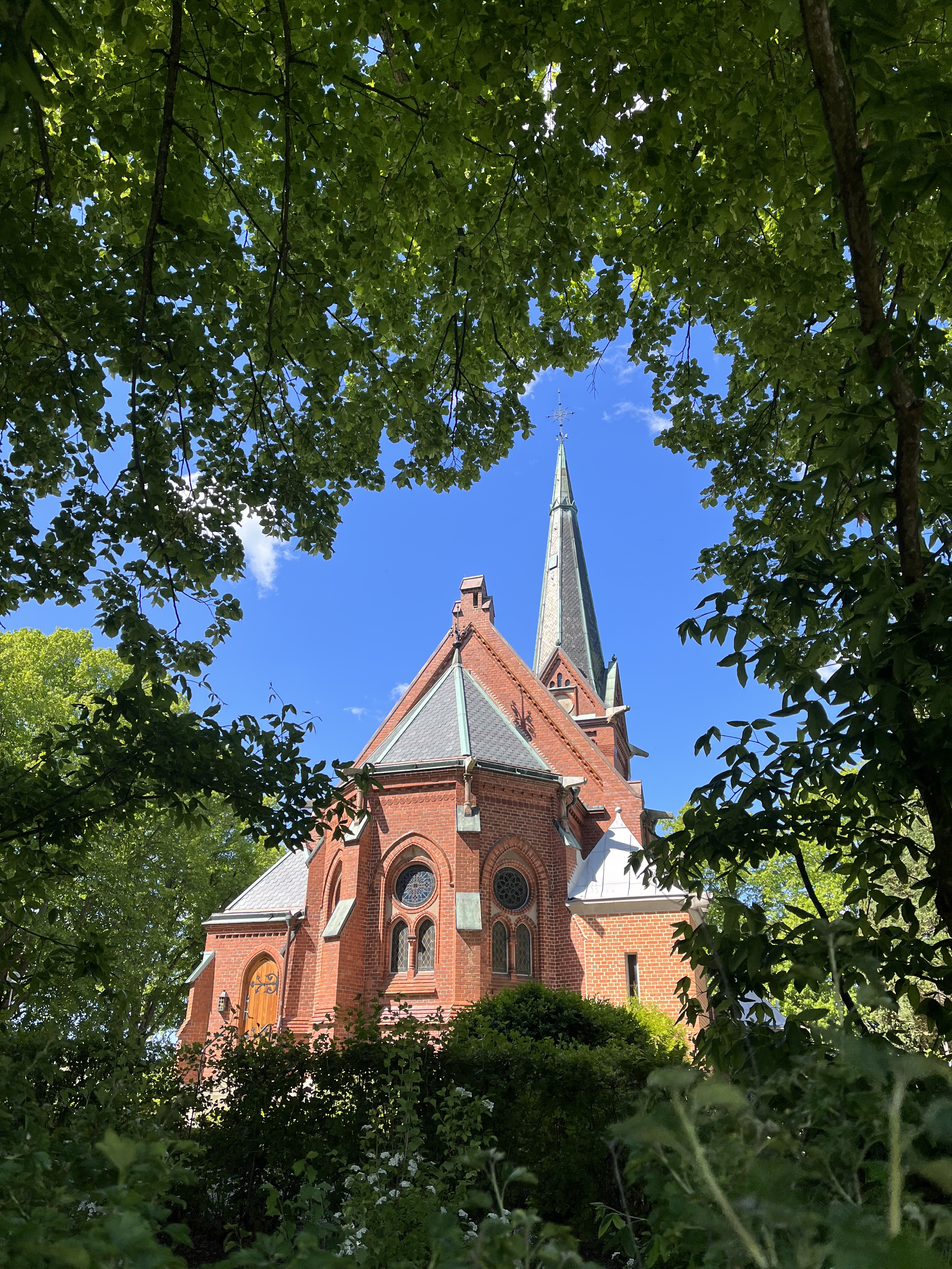 Norra Nöbbelövs kyrka exteriör med grönskande träd