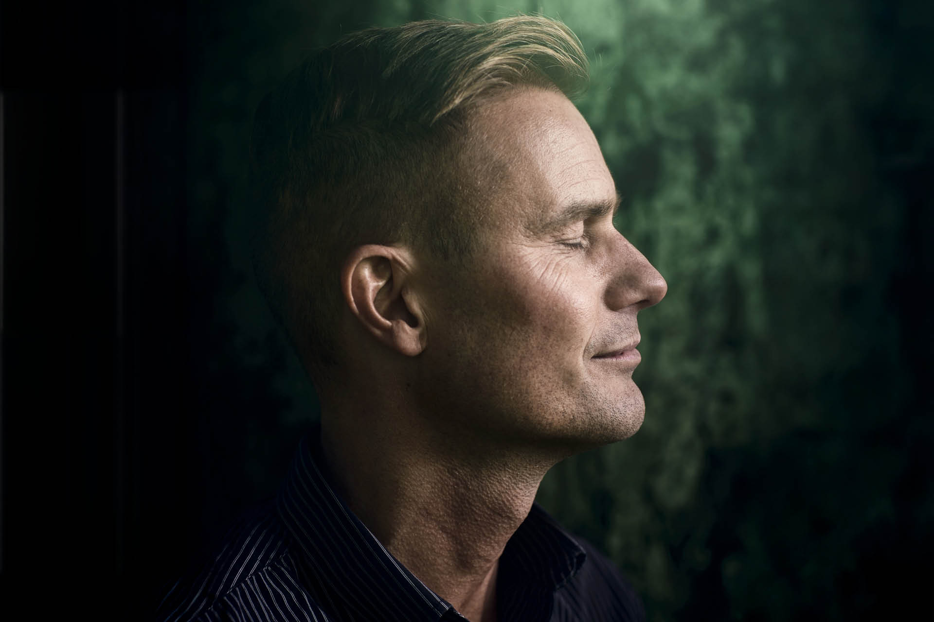Martin Hultman blundandes mot en svartgrön bakgrund