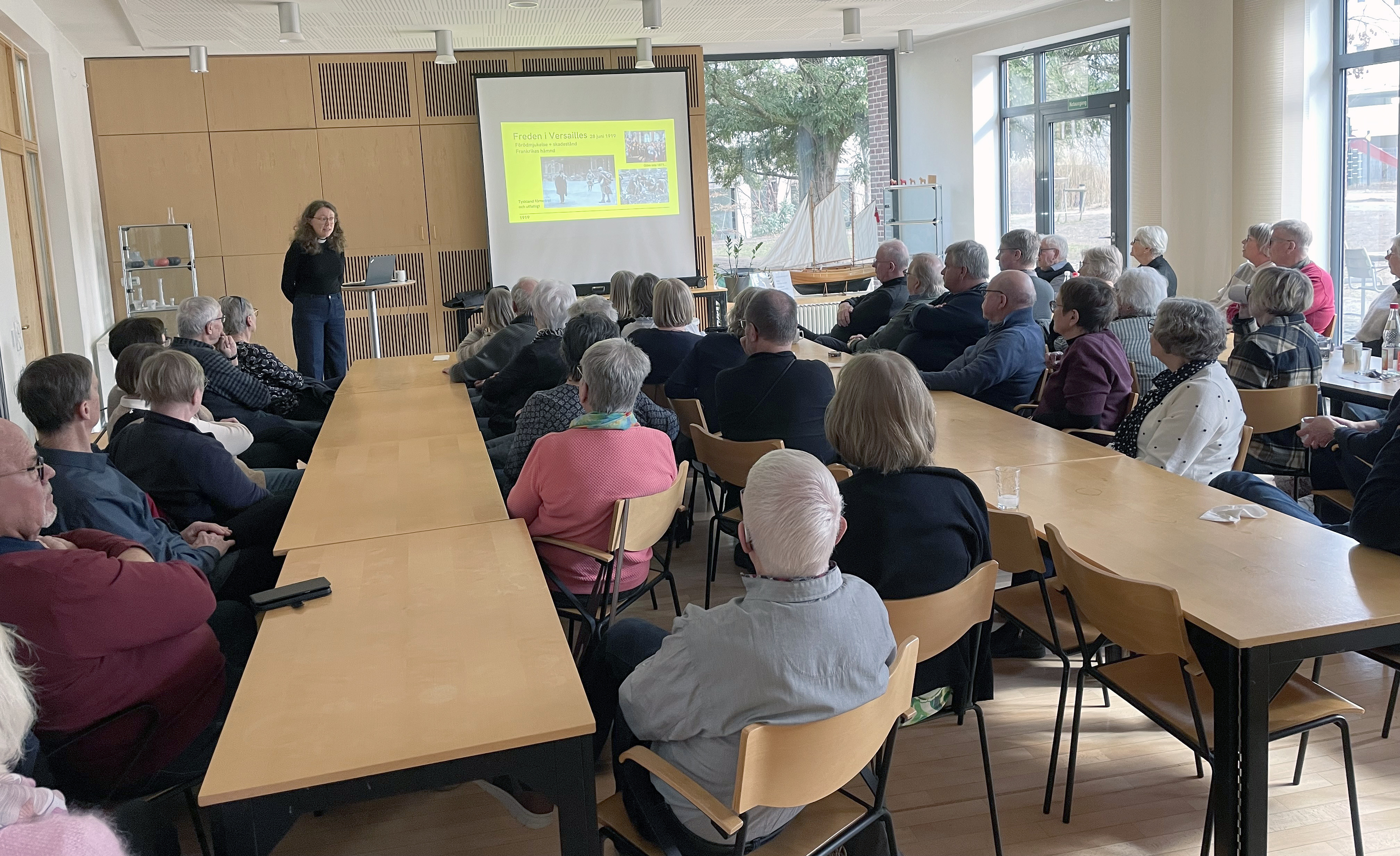 Grupp lyssnar på föredrag