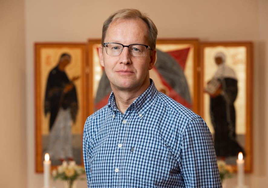 man med altartavla i bakgrunden