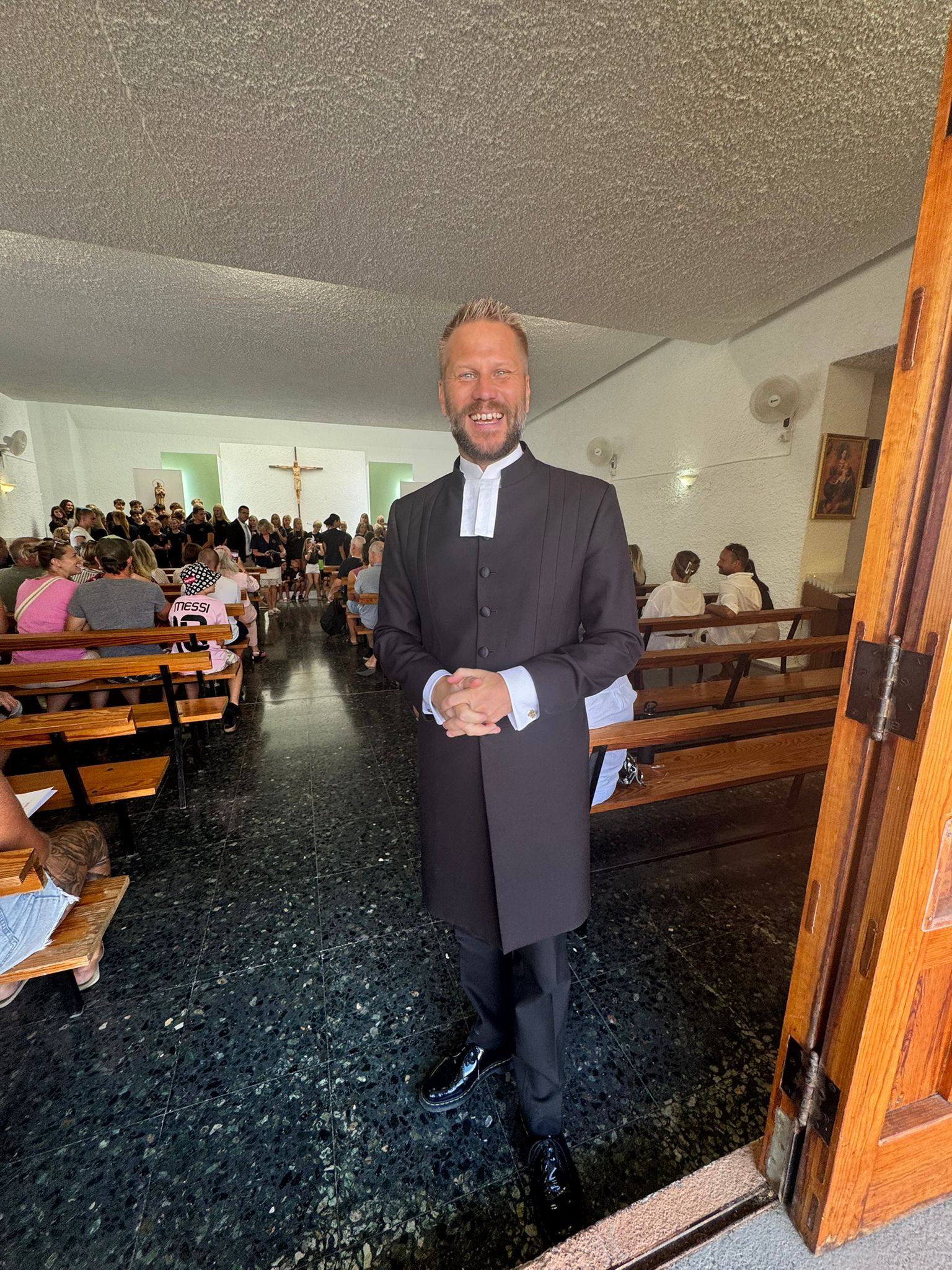 Gudstjänst i katolska kyrkan, San Agustin. Församlingsherde Victor Lindblom syns i förgrunden, och bakom honom kyrksalen fylld av gudstjänstbesökare.
