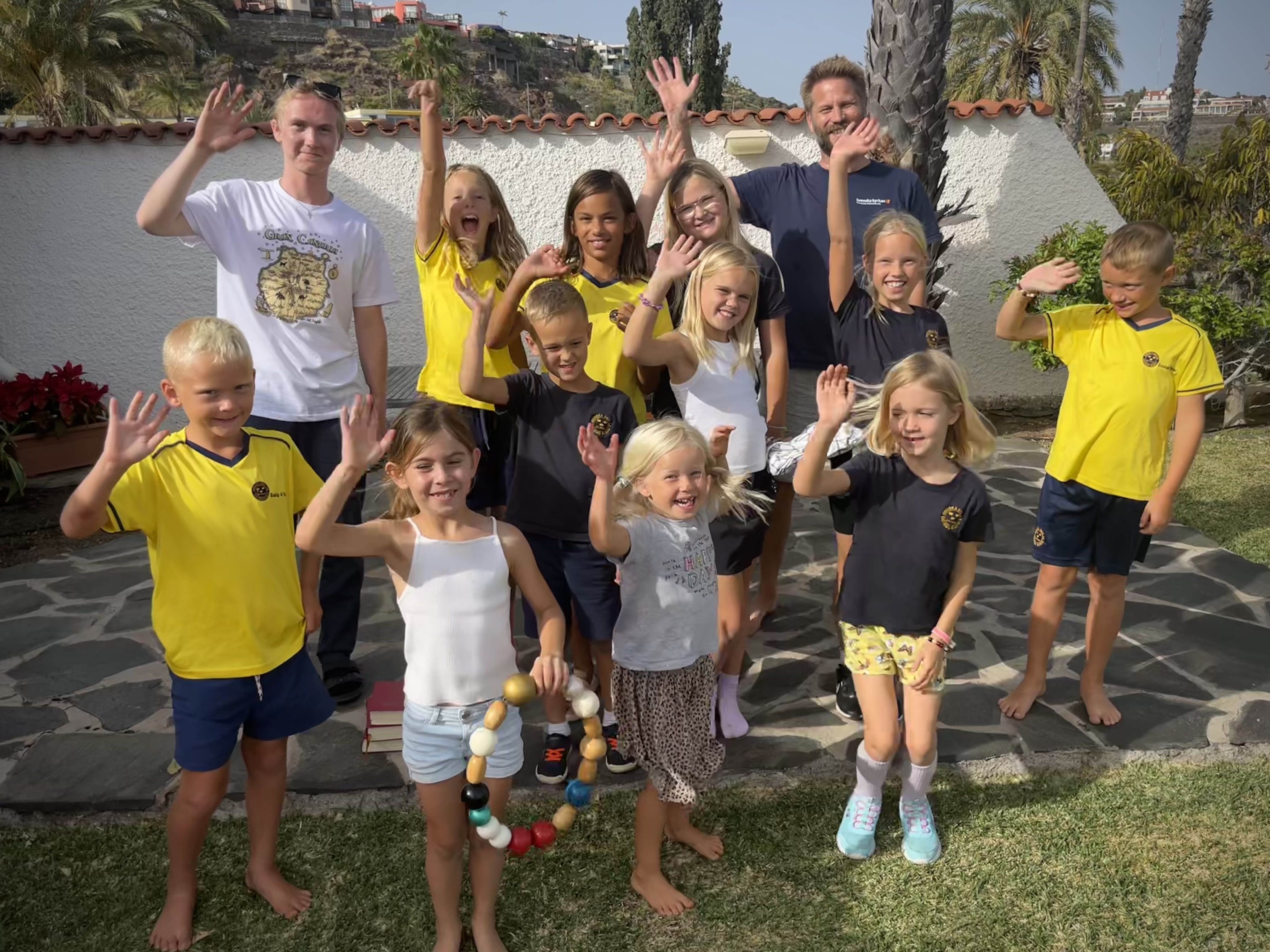 Barn och ledare från 'kyrkans barntimmar' vinkar glatt i solen på Gran Canaria.