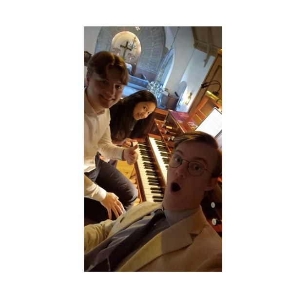 Tre organister syns framför en orgel