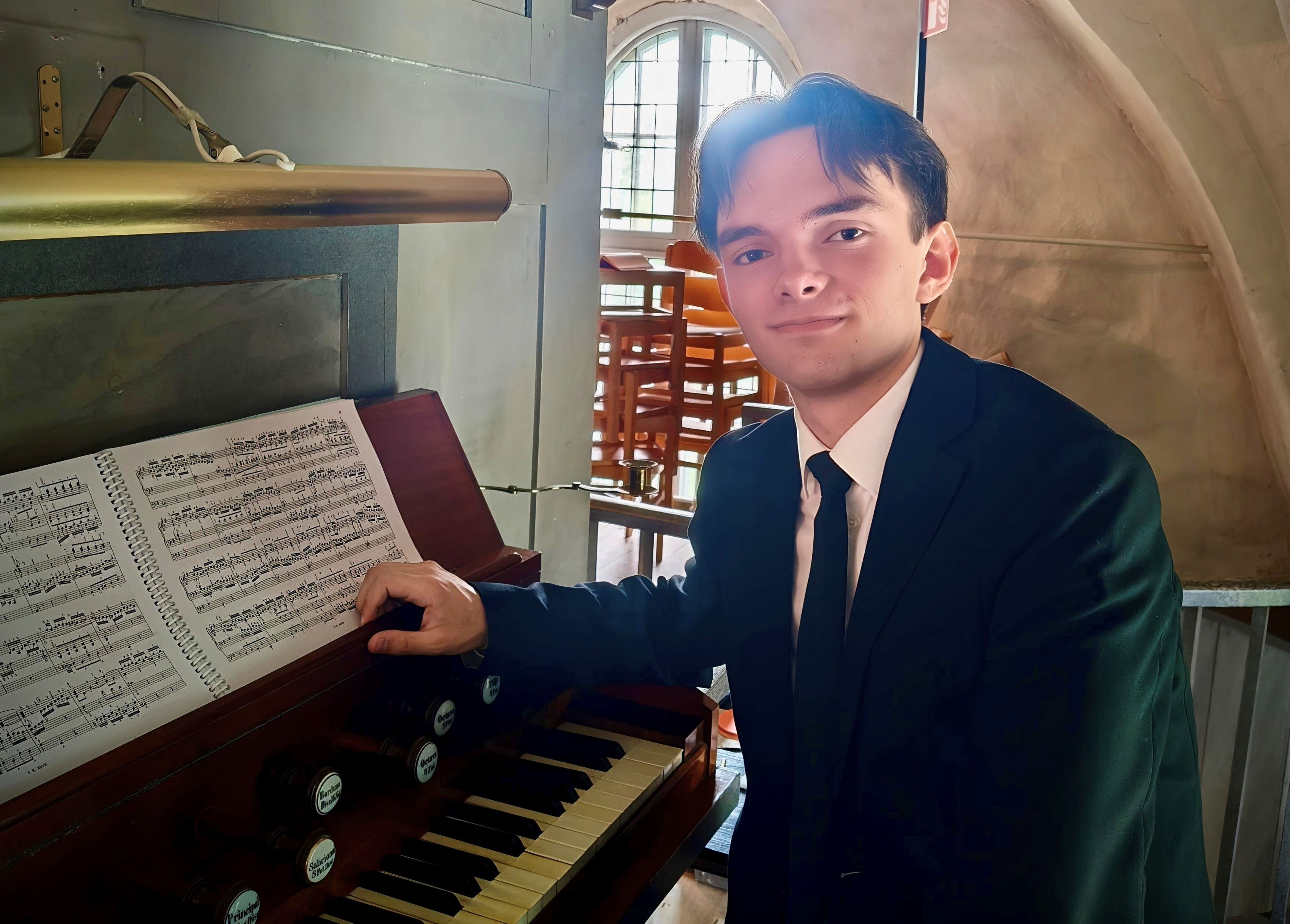 Ung organist sitter framför en orgel