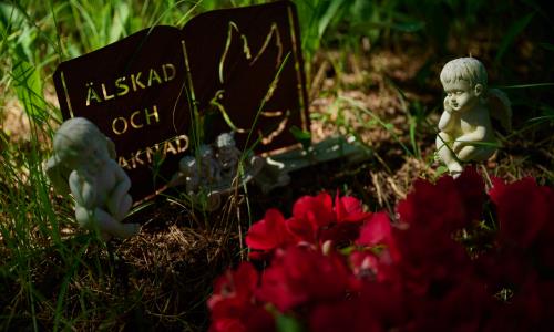 Grav med text Älskad och saknad, två änglar på varsin sida om stenen