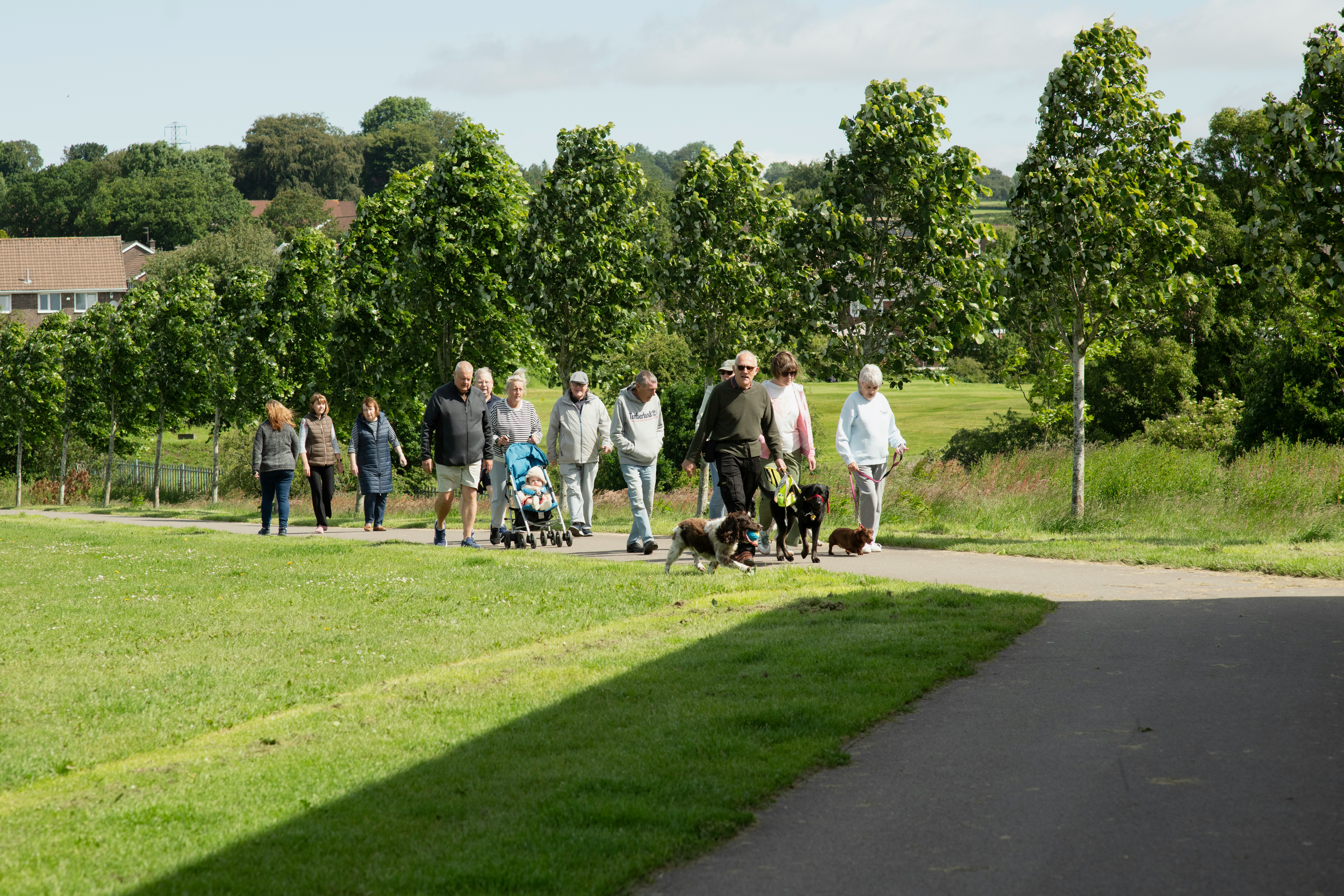 Grupp personer promenerar på en stig utomhus