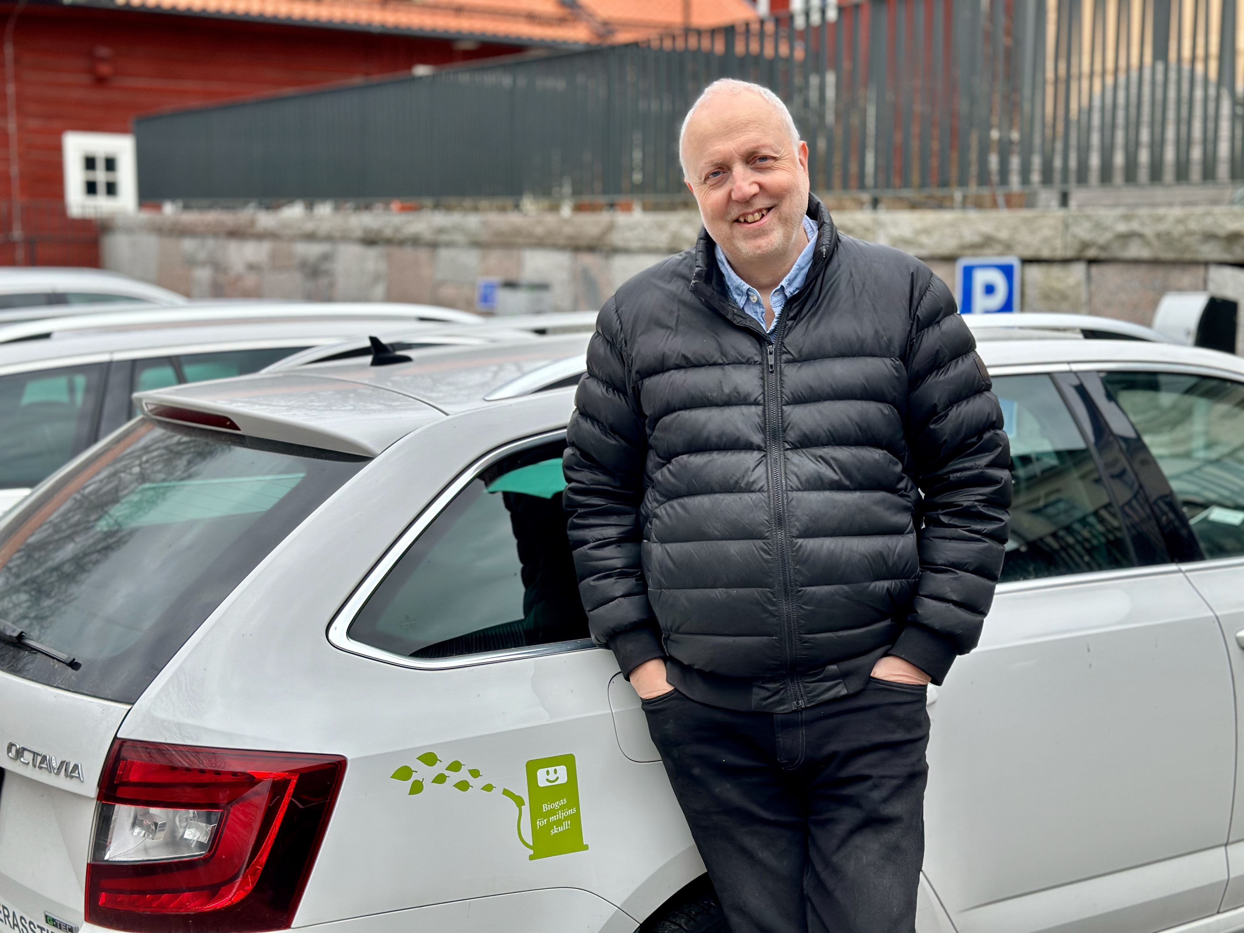 Åke Paulsson stående framför en av stiftets vita bilar