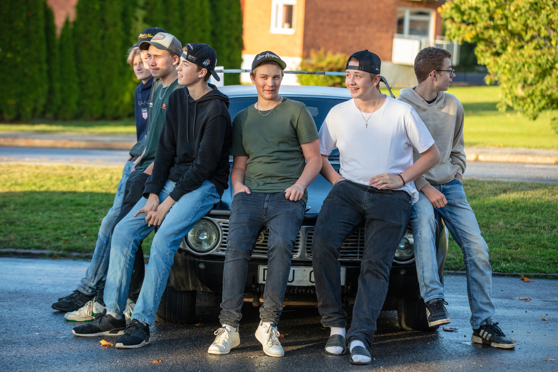 Grupp med ungdomar som sitter på huven på en Epa-traktor