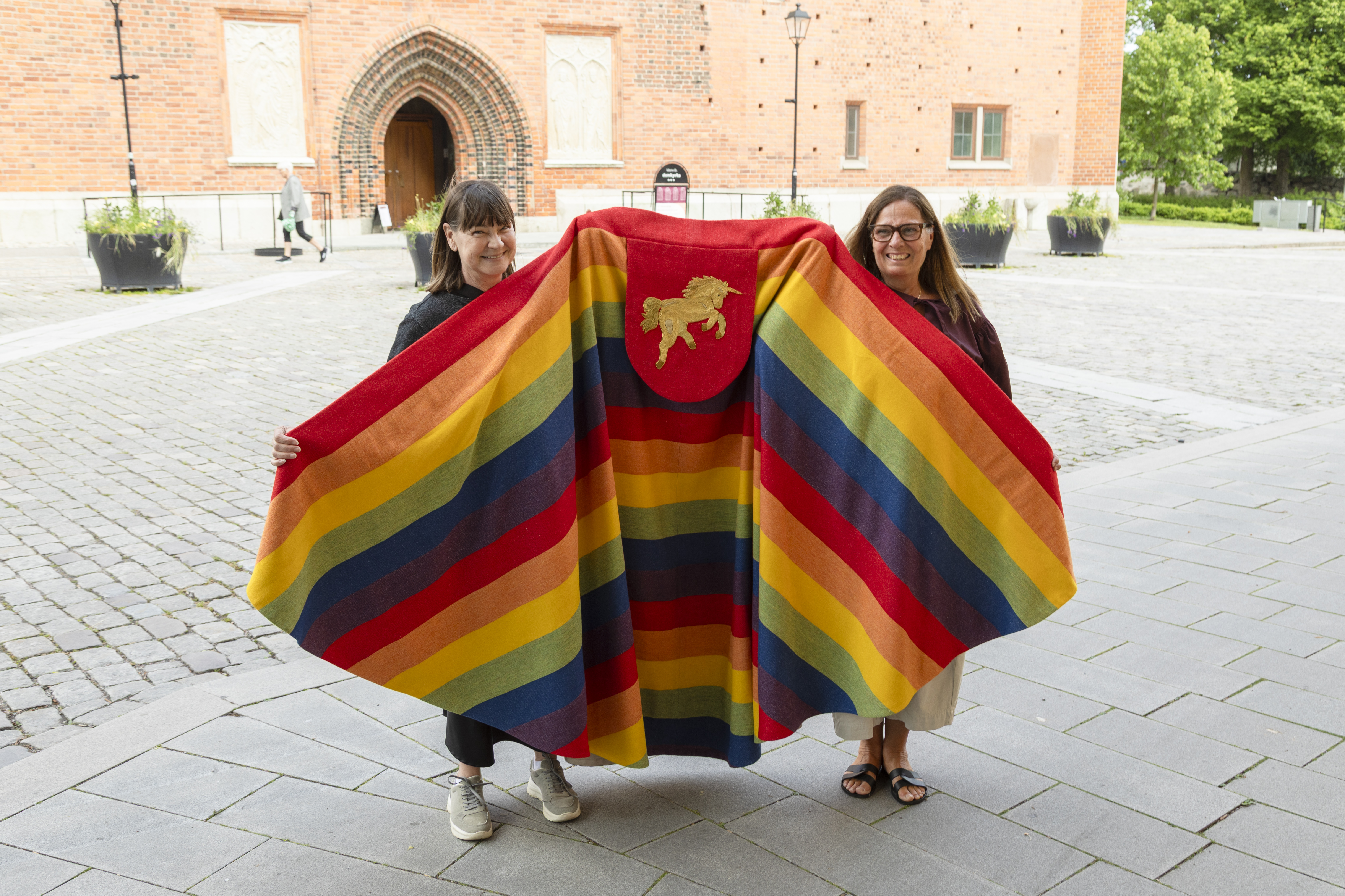 Damskräddarna Anette Andersson och Eva-Lena Lidström visar upp den nya korkårpan i regnbågens färger som de sytt
