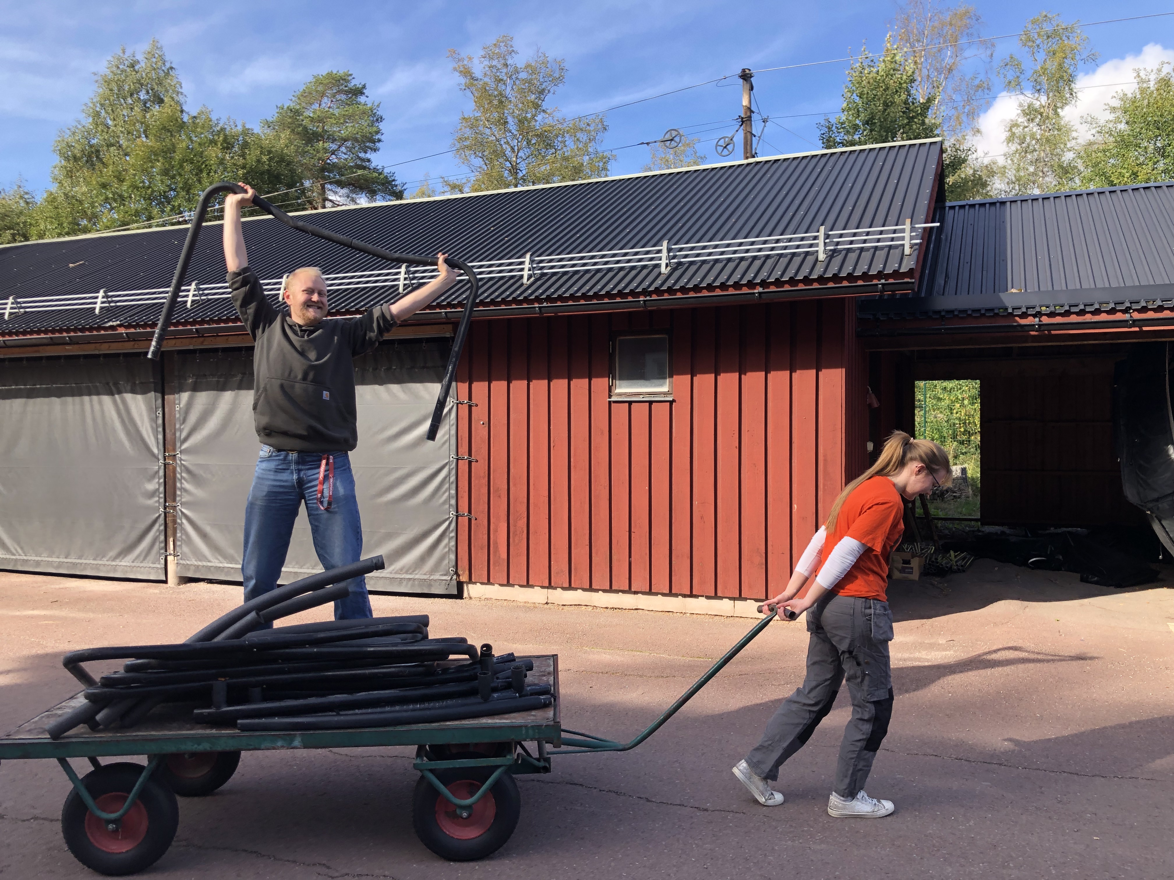 Kvinna drar vagn med en ståendes kollega i efter sig