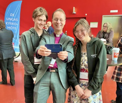 Biskop Mikael Mogren tar selfie med två ungdomar. 