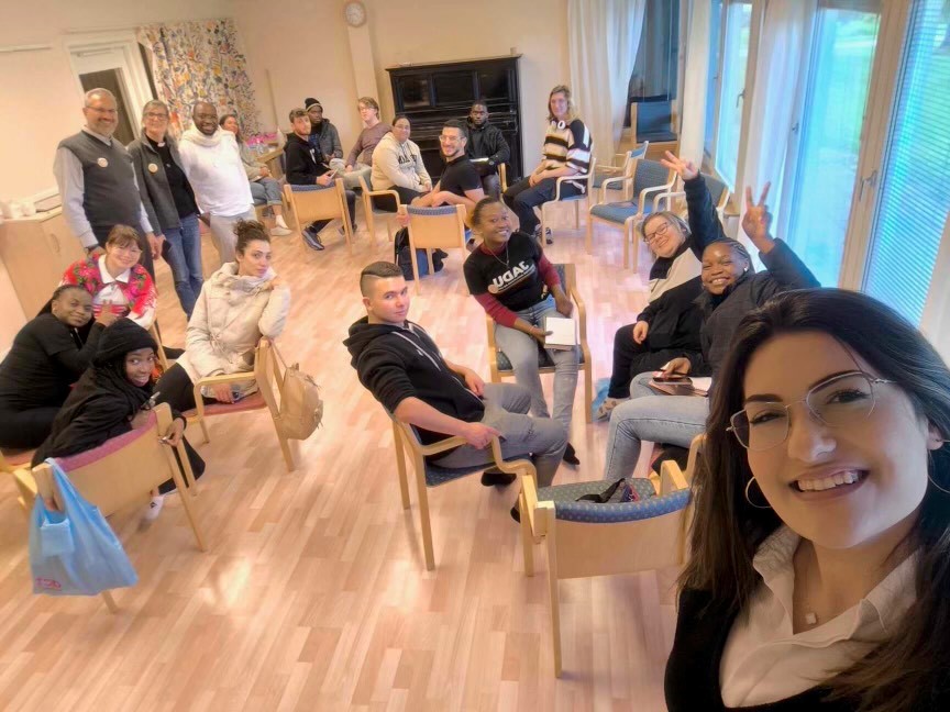 En grupp ungdomar som sitter uppdelade i mindre samtalsgrupper