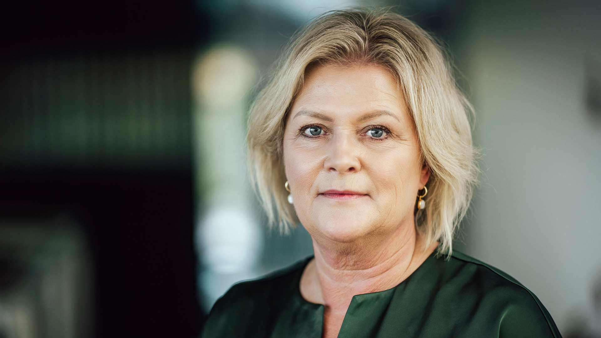 Kvinna med blont hår, klädd i svart blus.