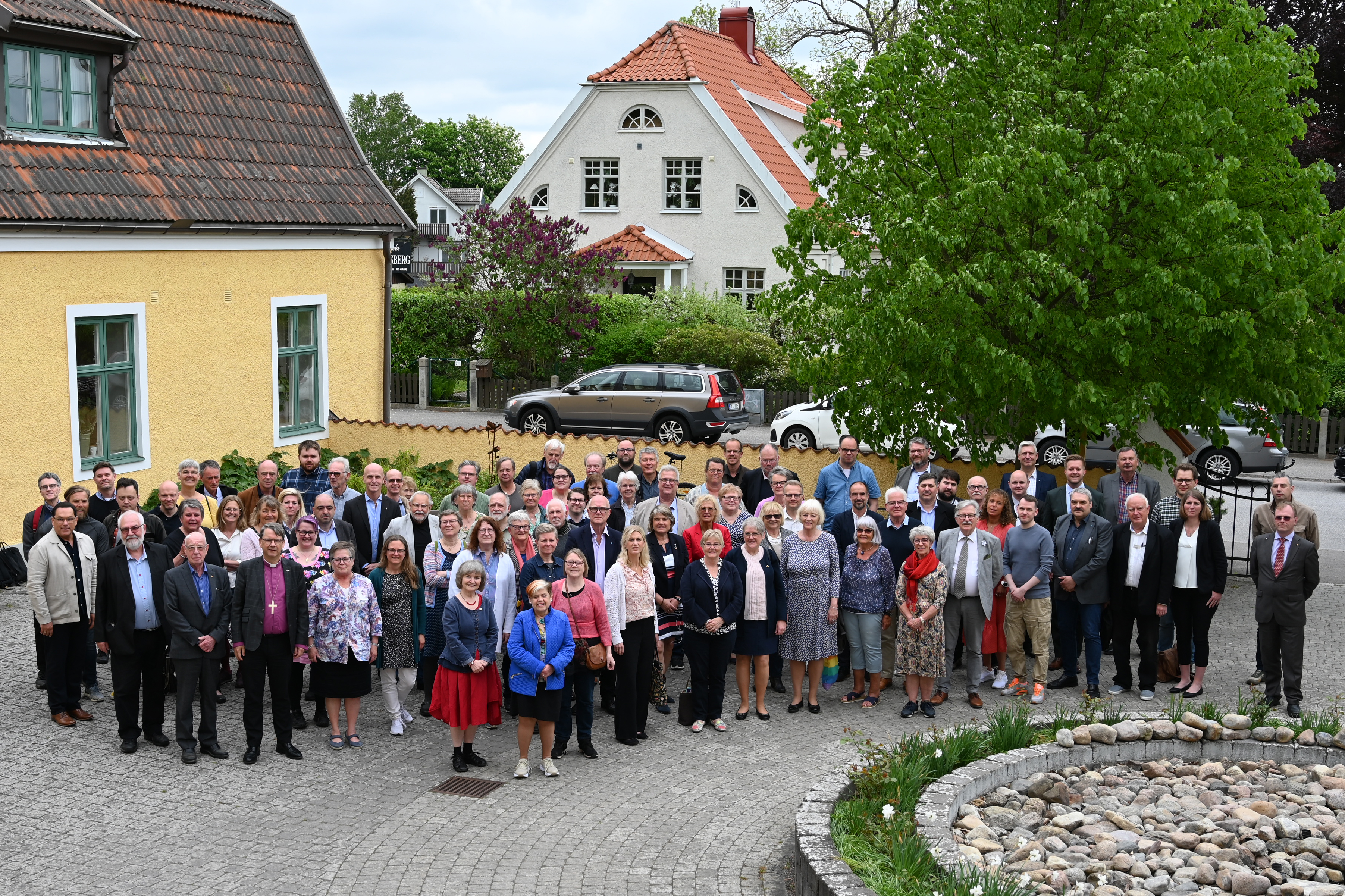 Människor framför ett gult hus