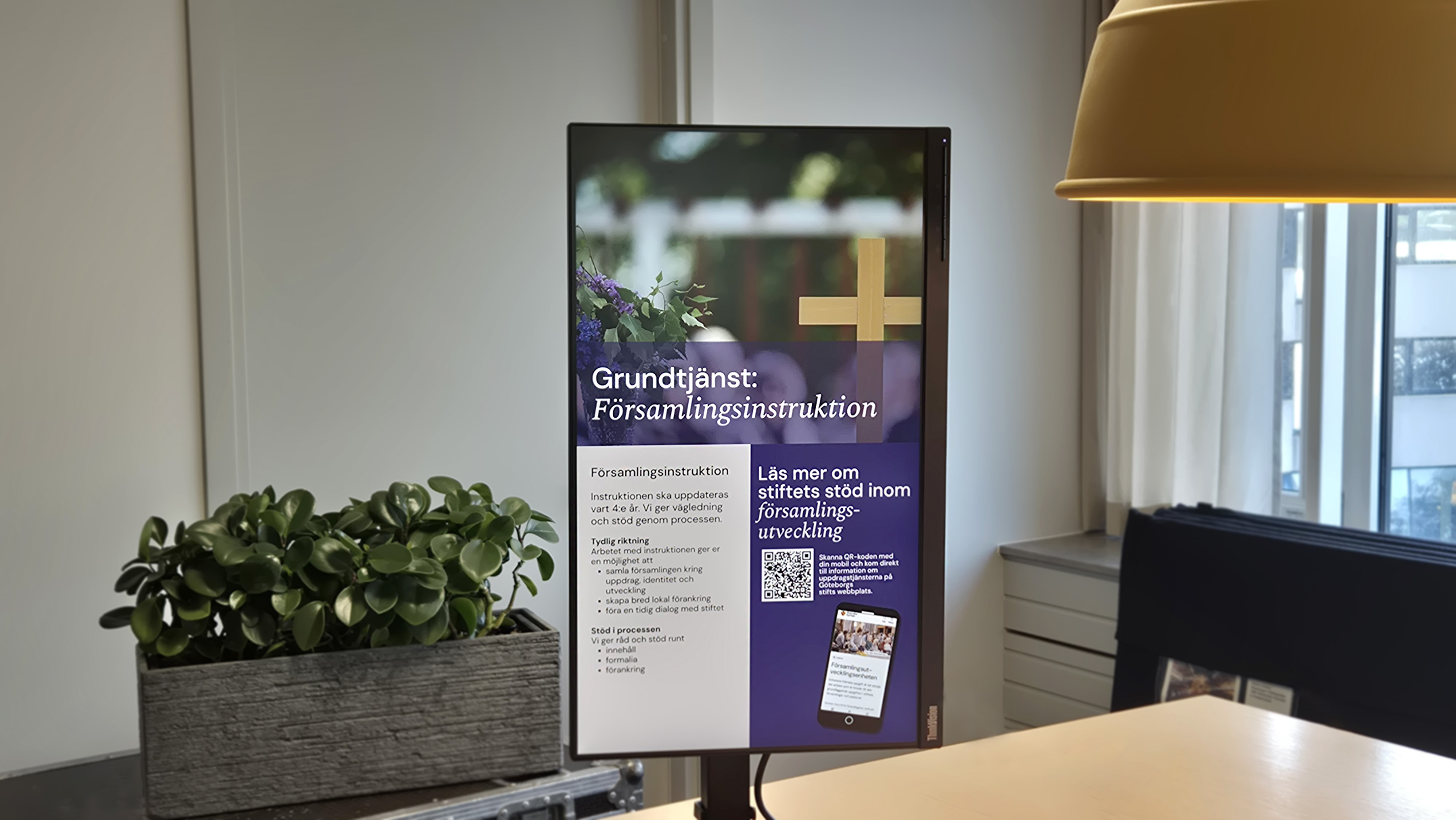 En digital skärm med innehåll, Kyrktavlan, står på ett bord.