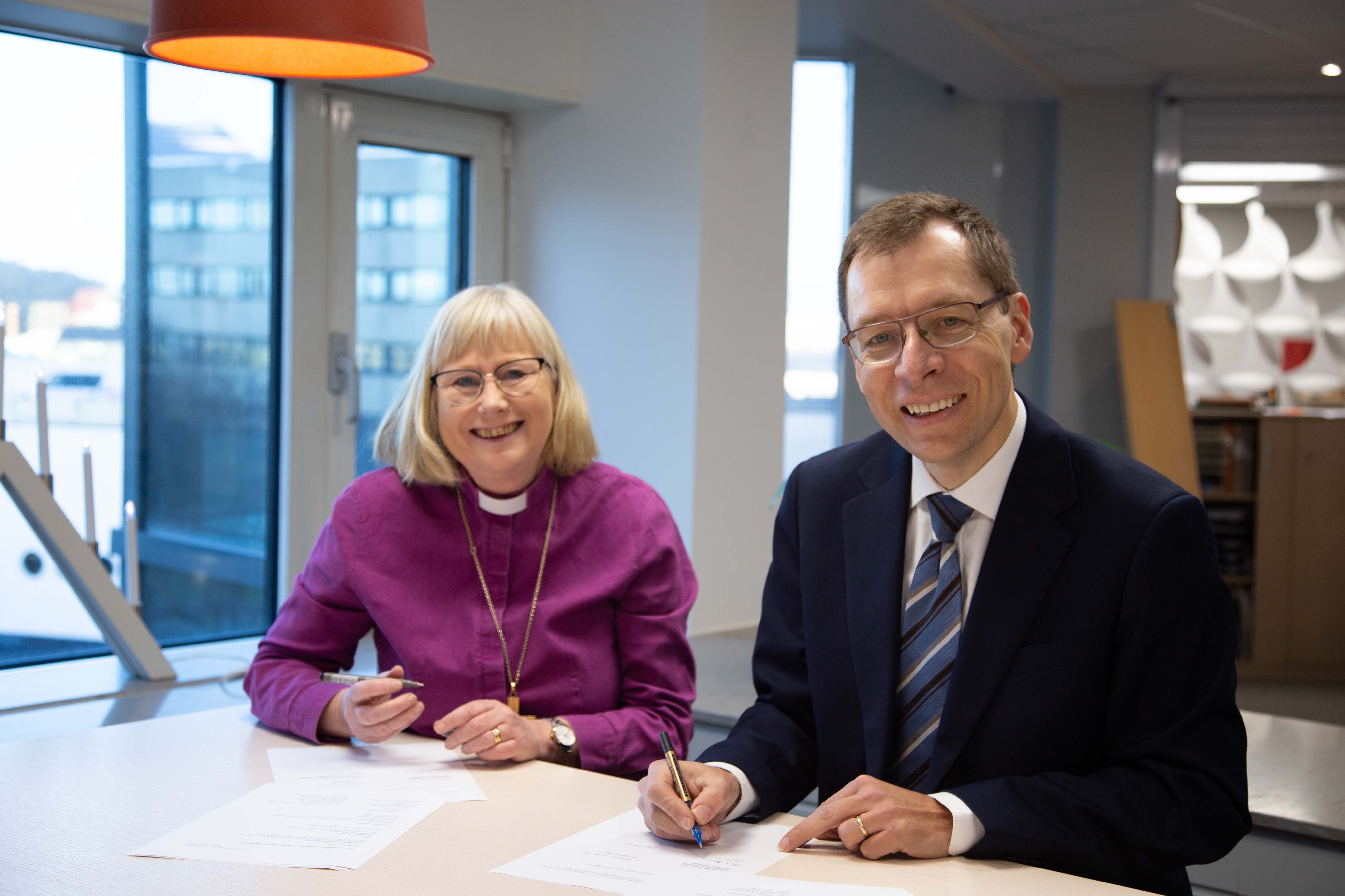 Susanne Rappmann, biskop i Göteborgs stift och Tobias Hägerland, prefekt vid Institutionen för litteratur, idéhistoria och religion vid Göteborgs universitet skriver under samarbetsavtalet.