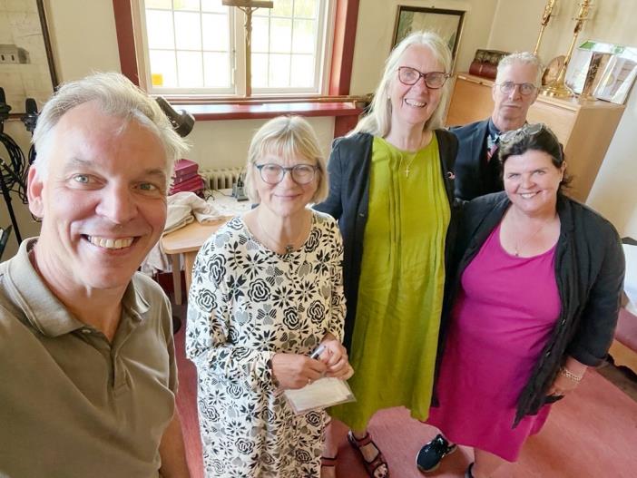 En grupp människor i Floby pastorat ler varmt mot kameran.