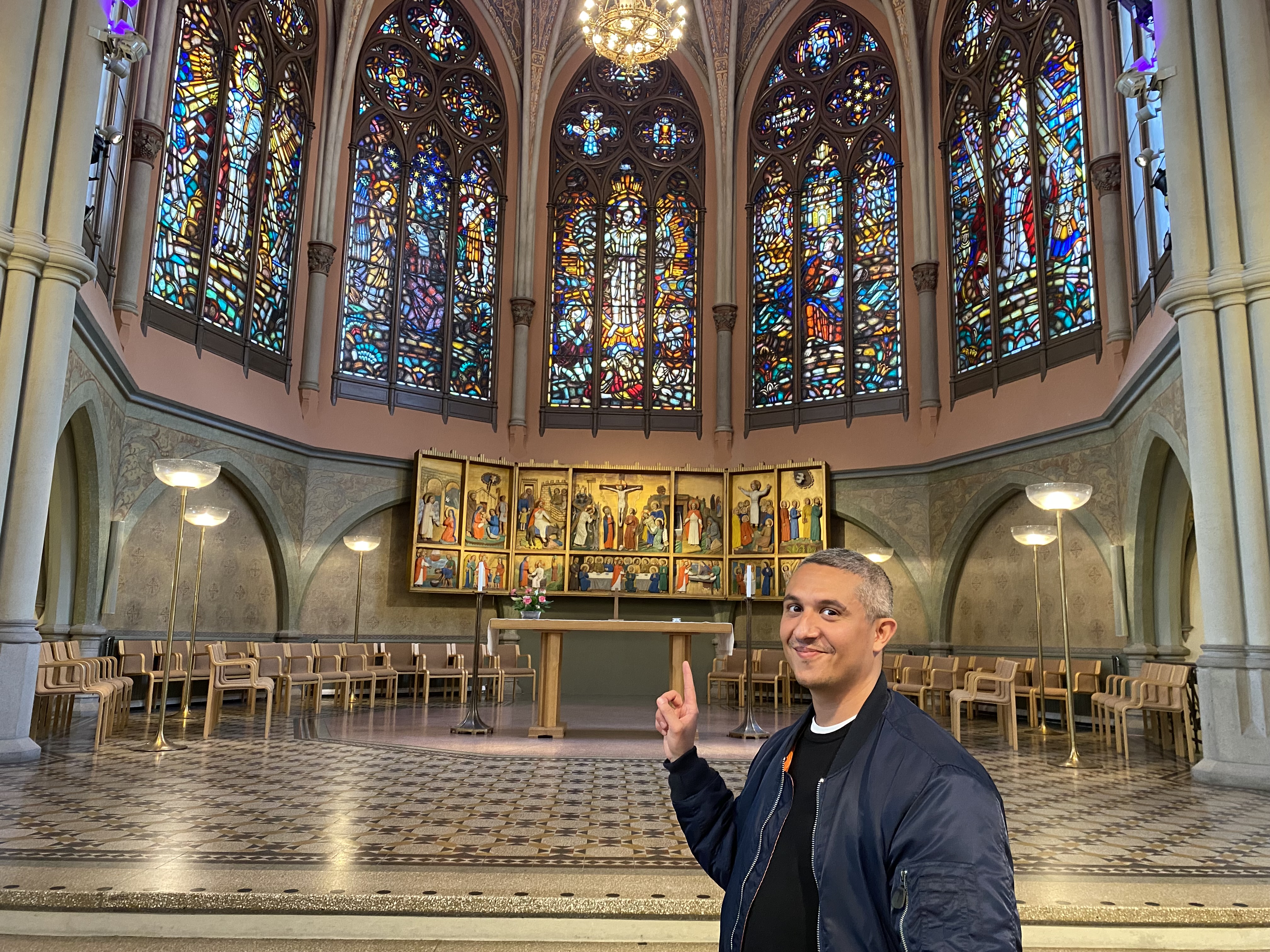 Josef i en kyrka och pekar mot fönstren