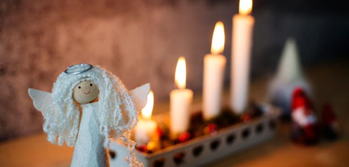 Ängel framför adventsljusstake