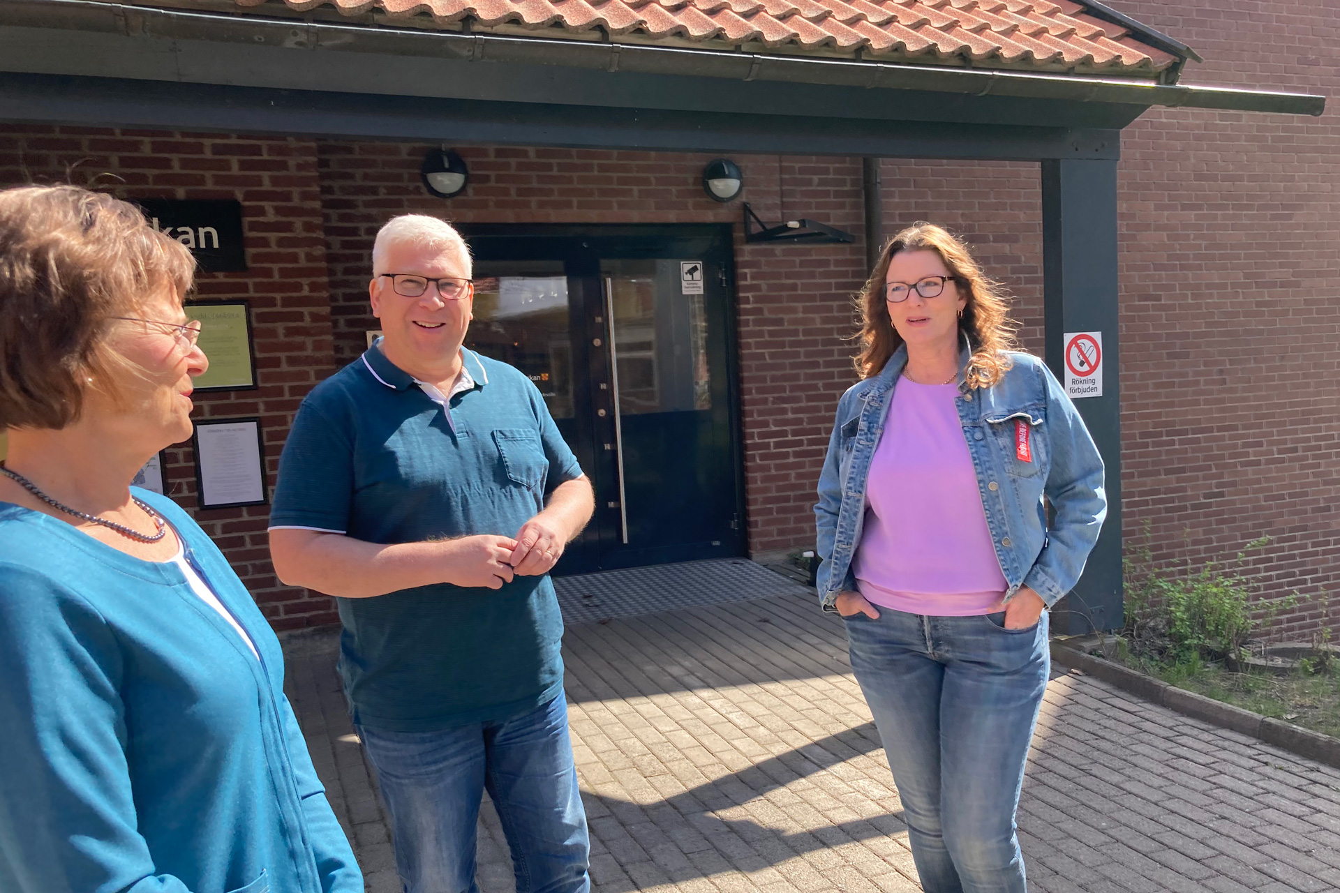 Tre körsångare utanför Dalabergskyrkan. 