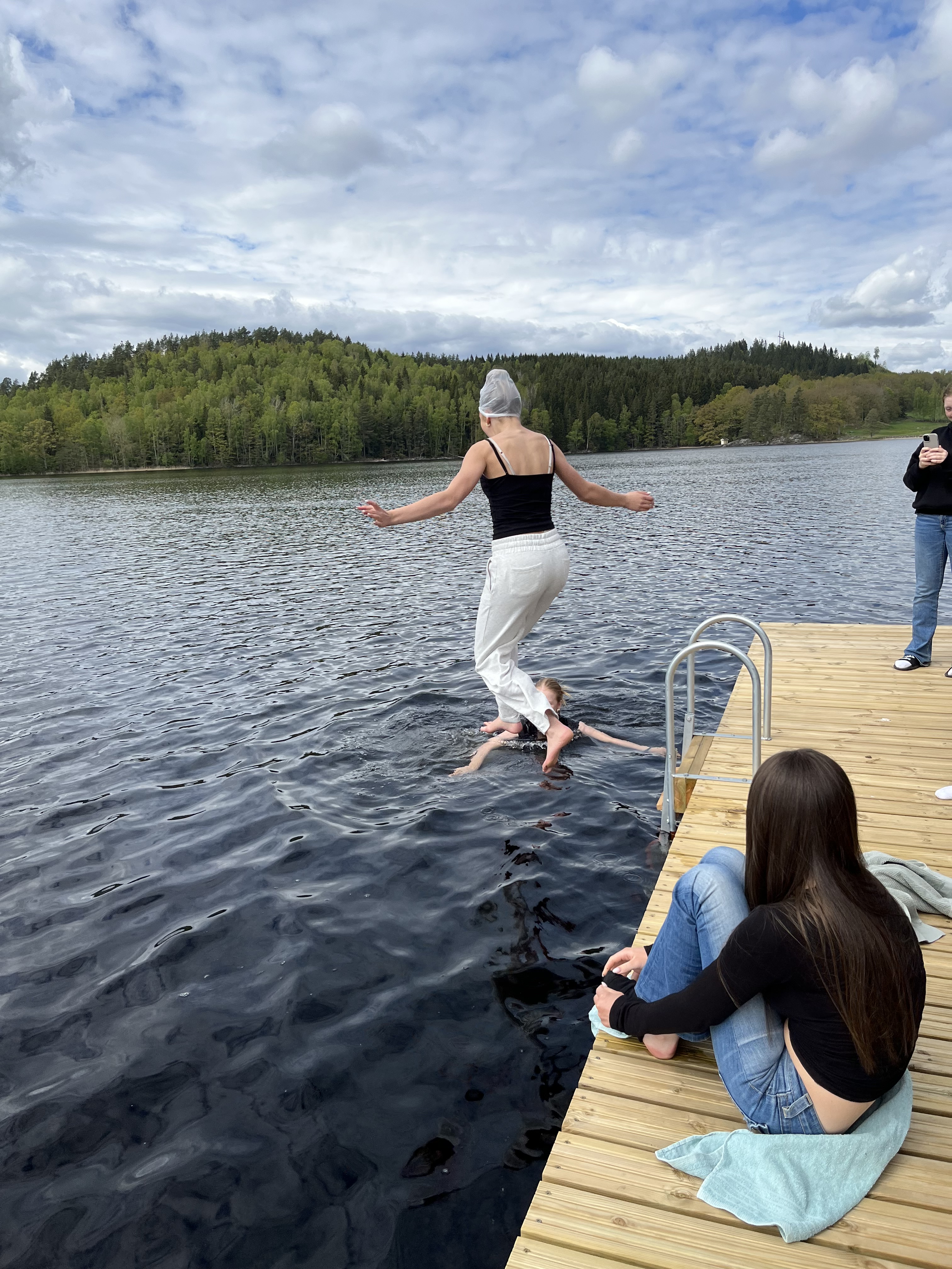 Tjej som hoppar i vattnet med kläderna på