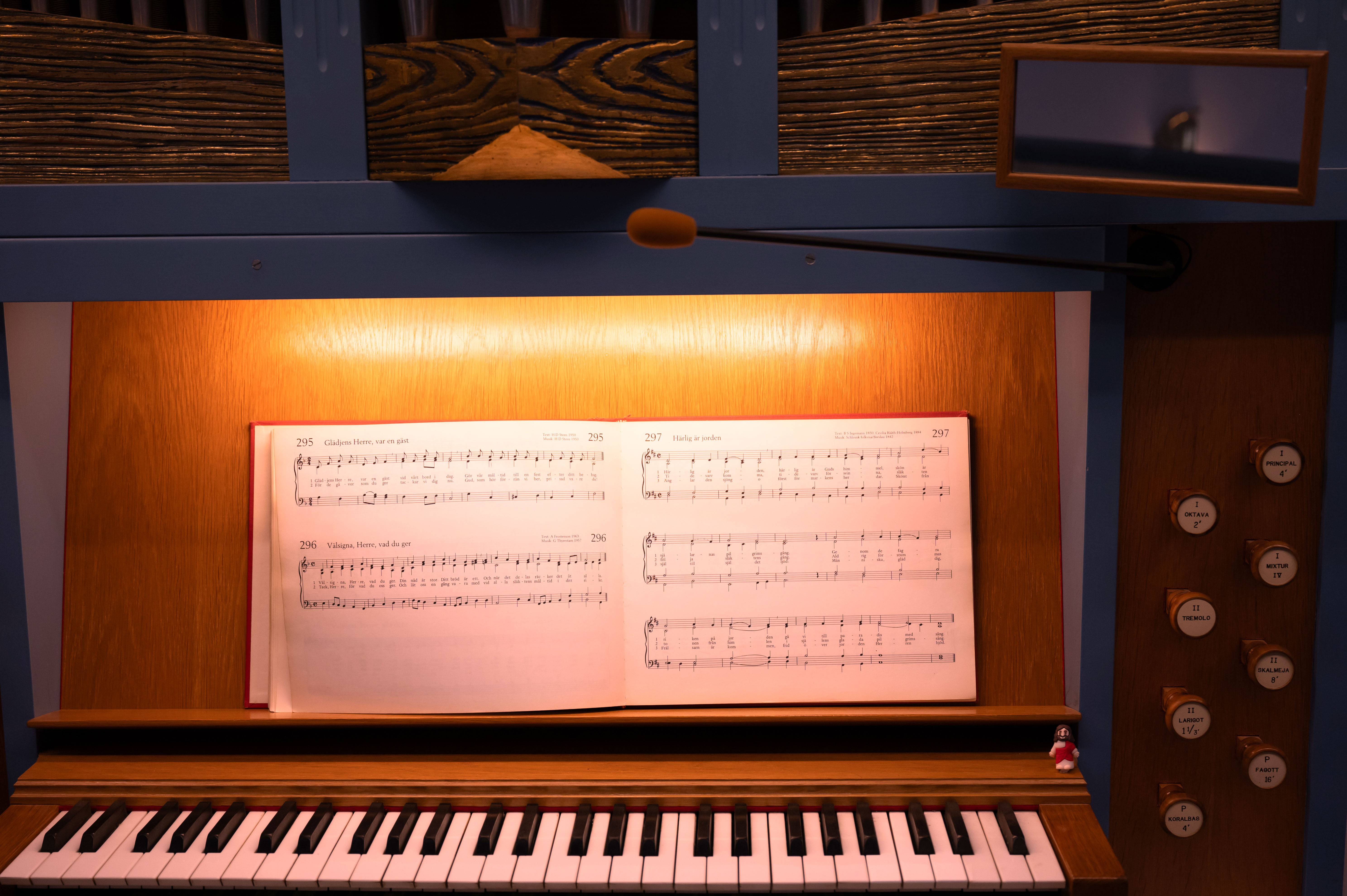 Närbild på en kyrkorgel. En koralbok står uppslagen på notstället ovanför tangenterna.