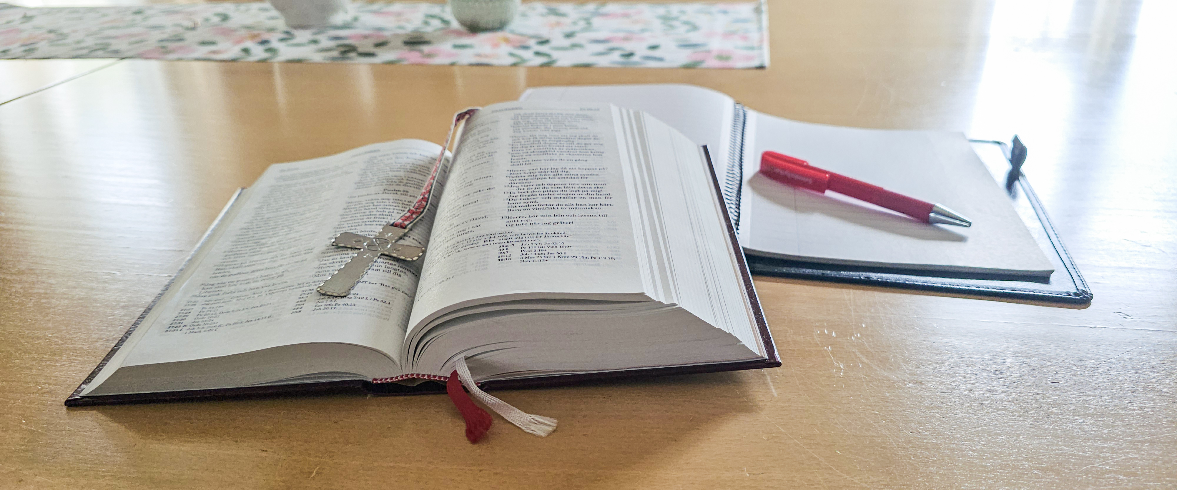 Bibel och anteckningsbok på ett bord