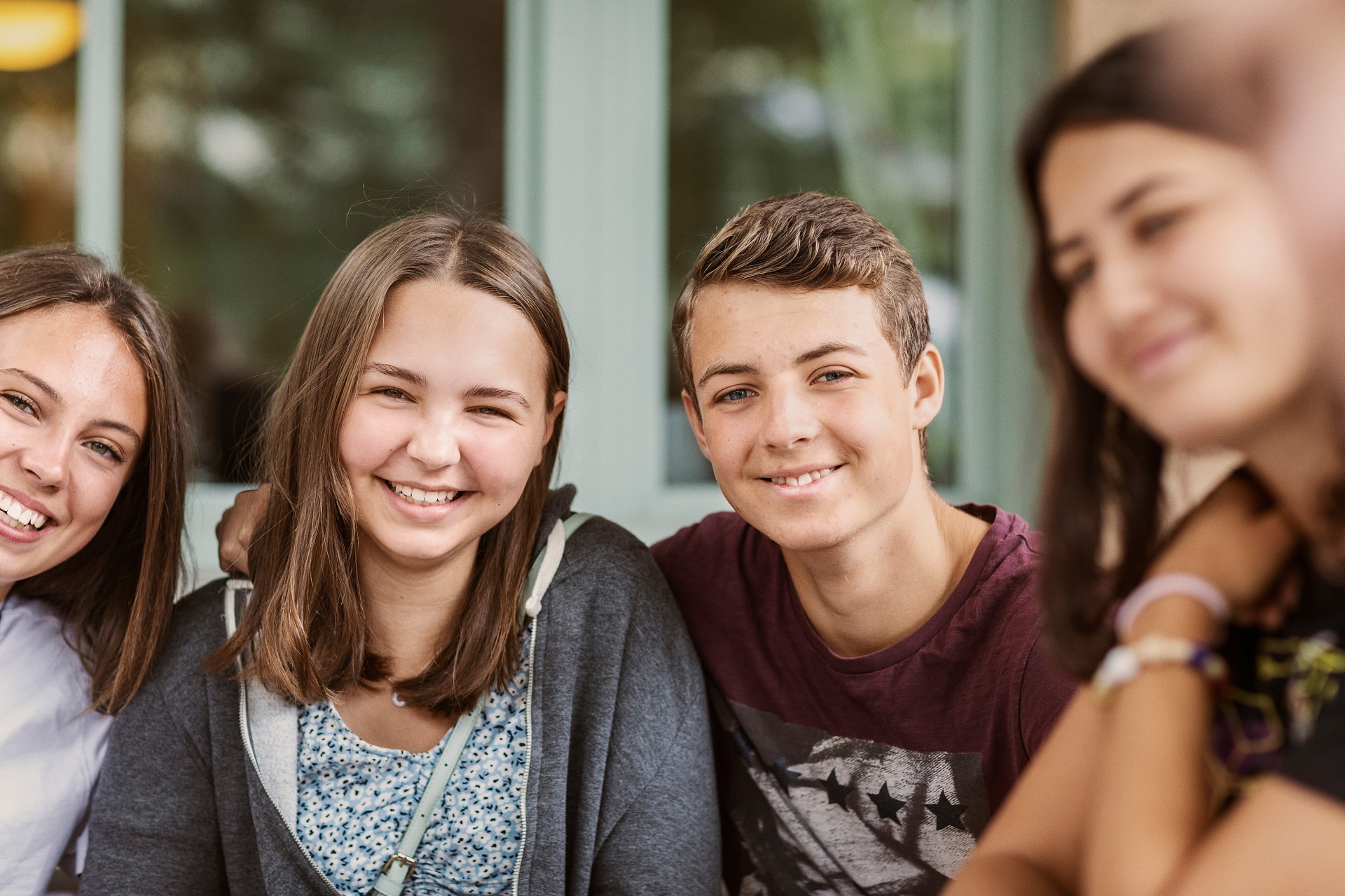 Fyra glada ungdomar som tittar in i kameran