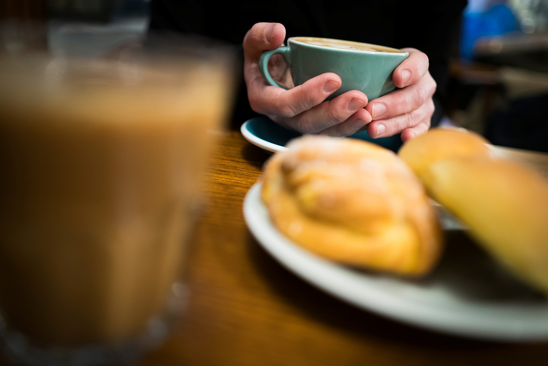 Närbild på en hand som håller en kaffekopp.