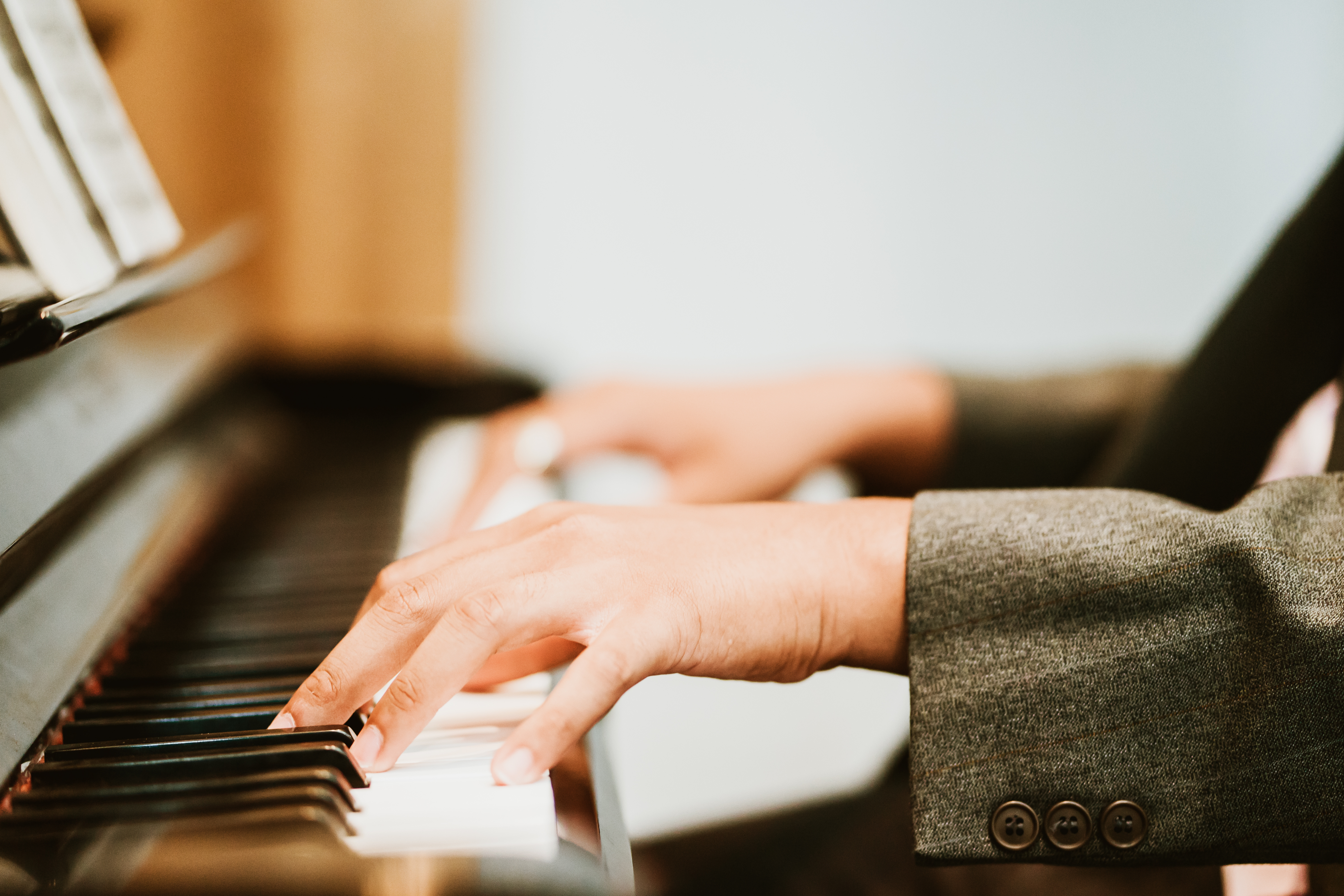 Händer som spelar på ett piano, närbild.