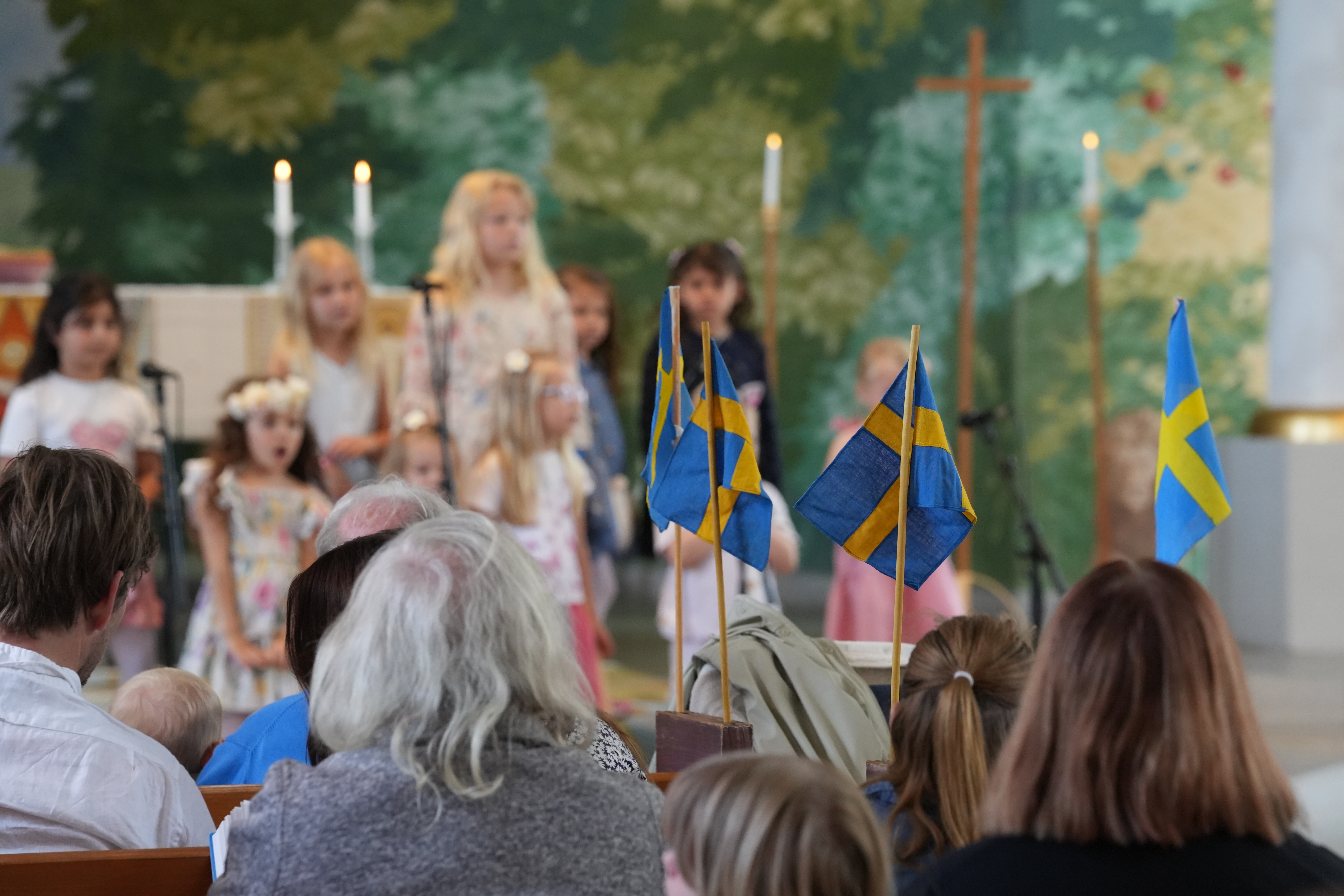 Besökare i förgrunden och barnkör som sjunger i bakgrunden