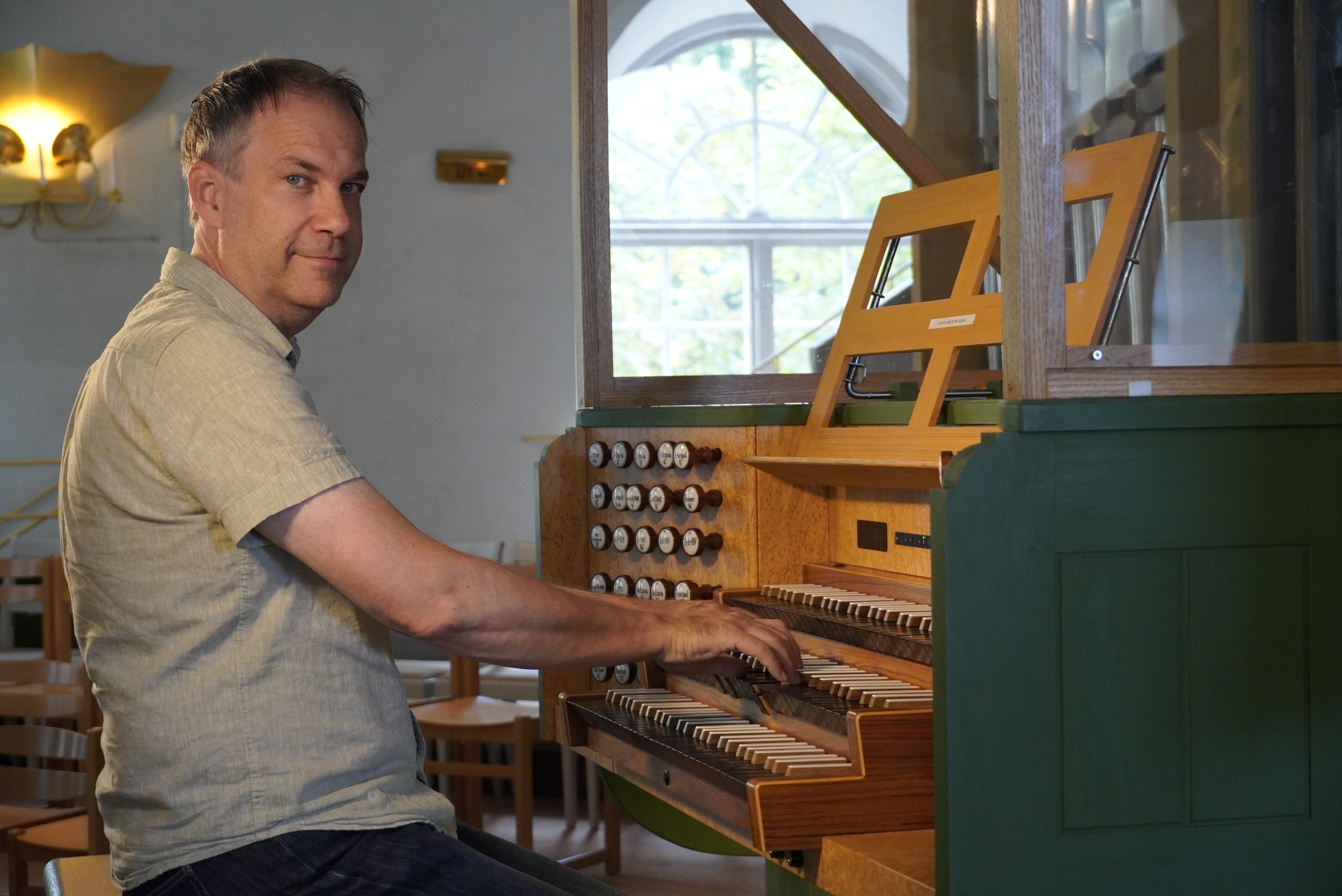 Lars-Ove sitter vid stora orgeln i Kumla kyrka.