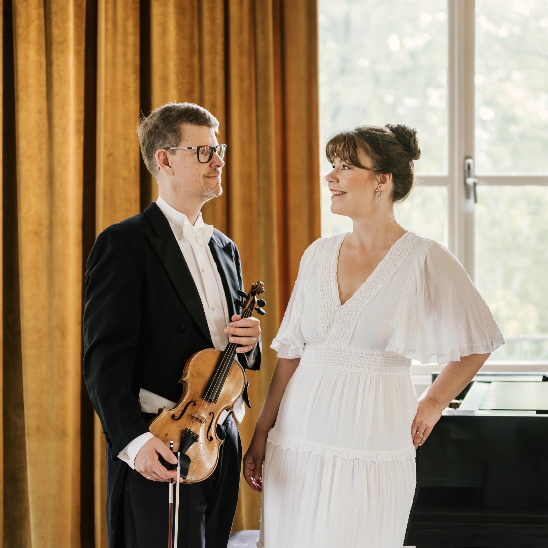 Roger och Elain Olsson står framför ett fönster