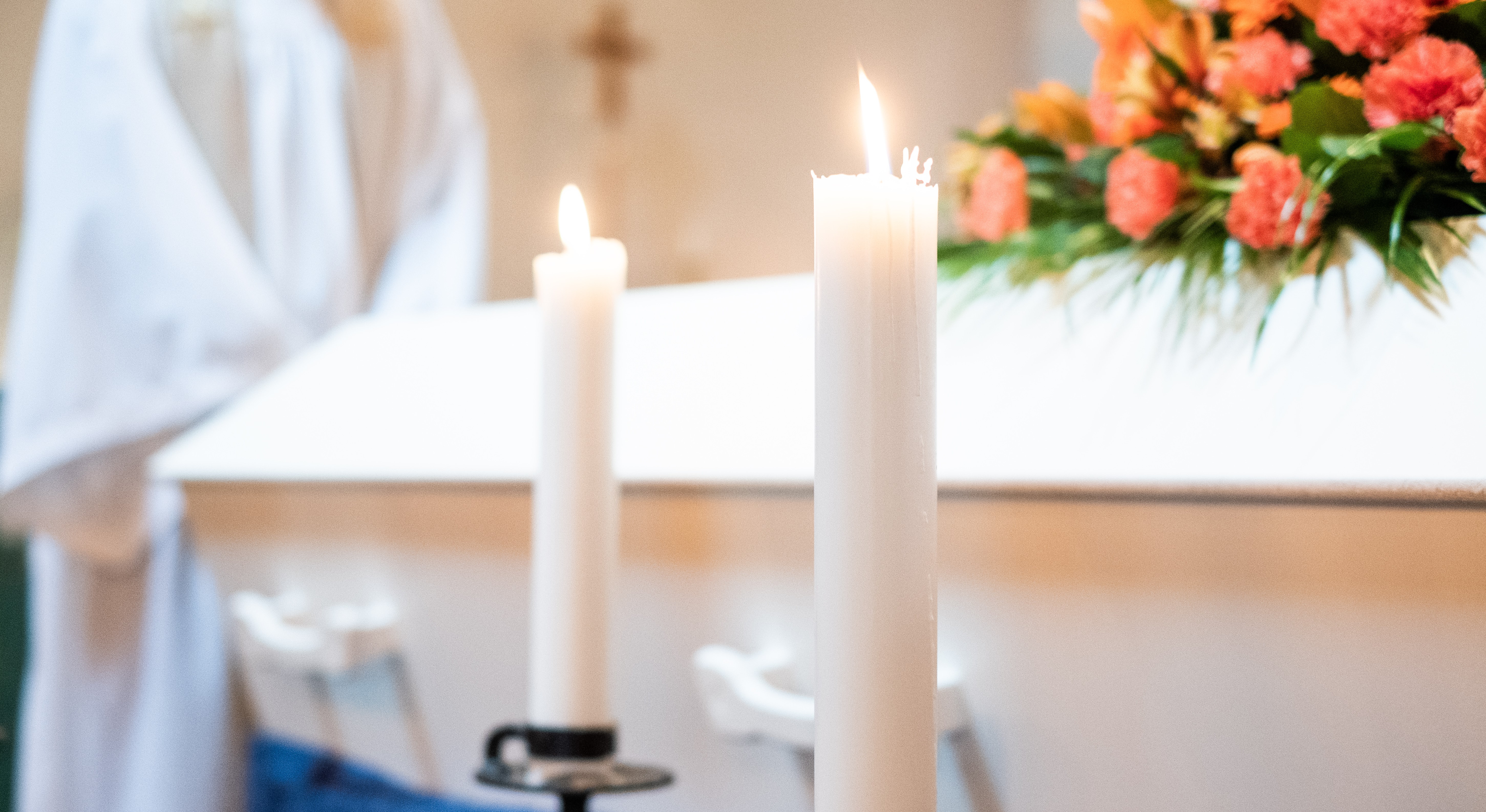 Vit kista med blommor och ljus