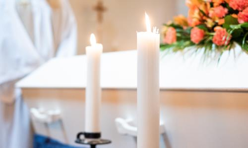 Vit kista med blommor och ljus